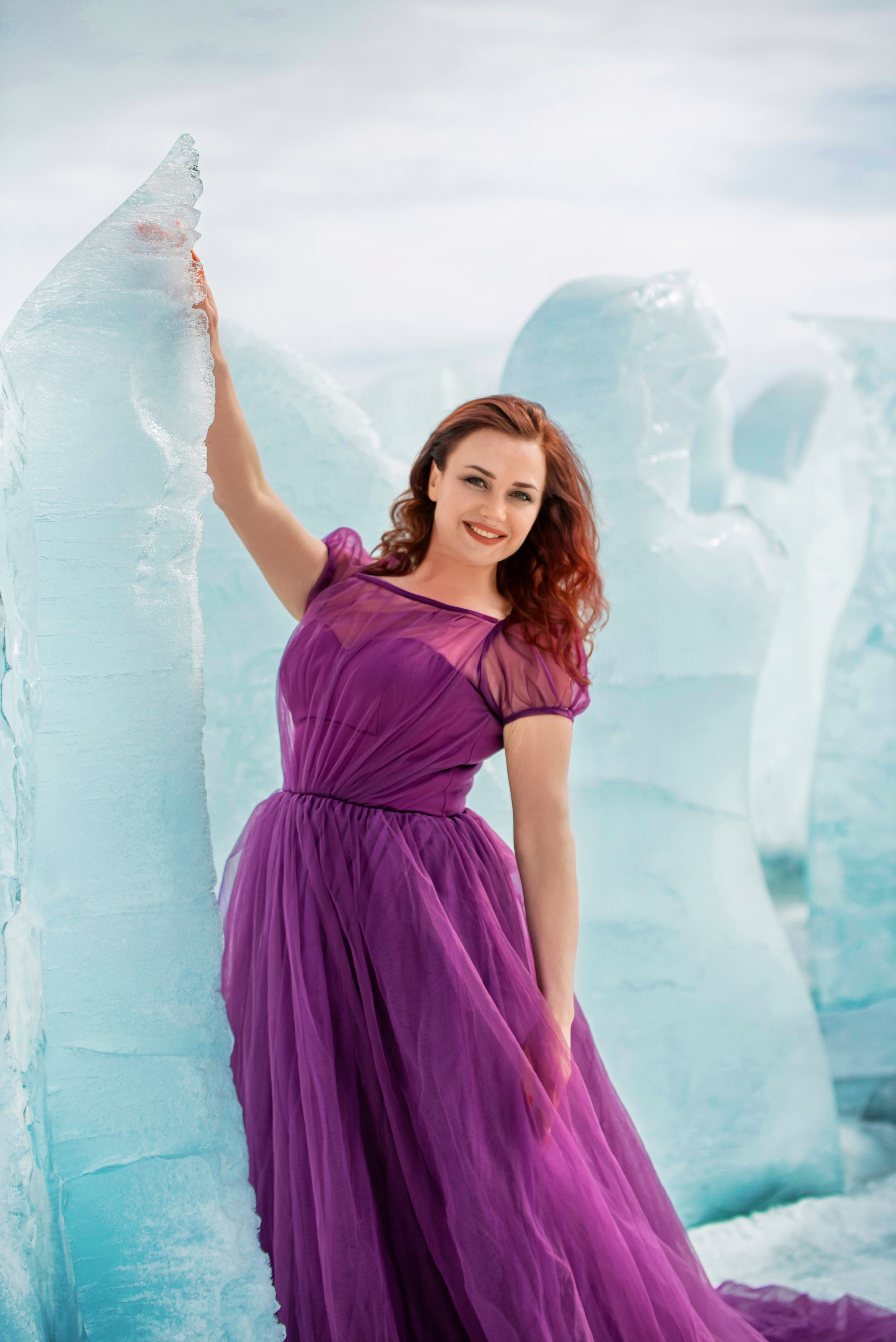 Девушка в платье их фатина фиолетового цвета на фоне льда
