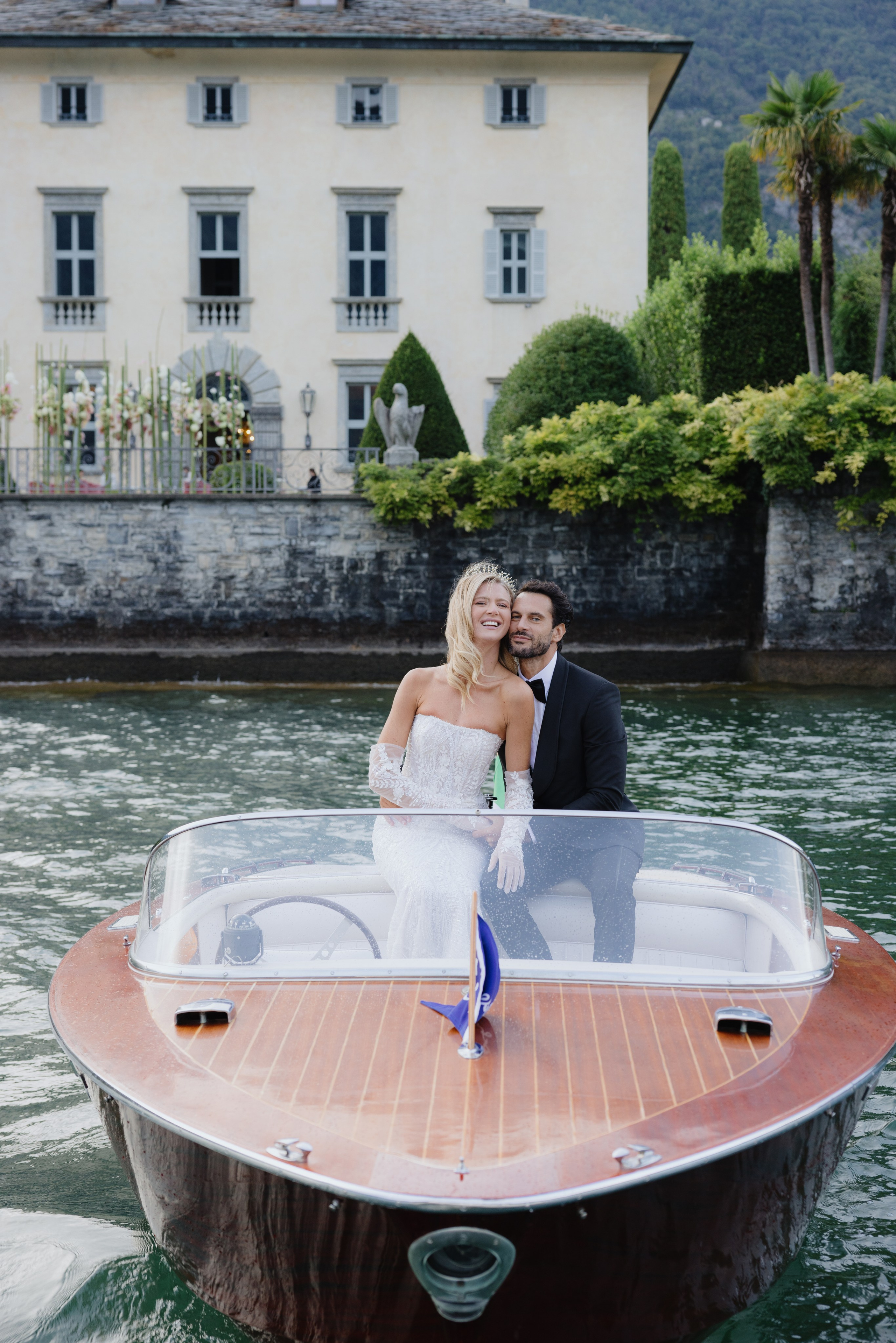 Bride standing in a vintage boat on Lake Como
