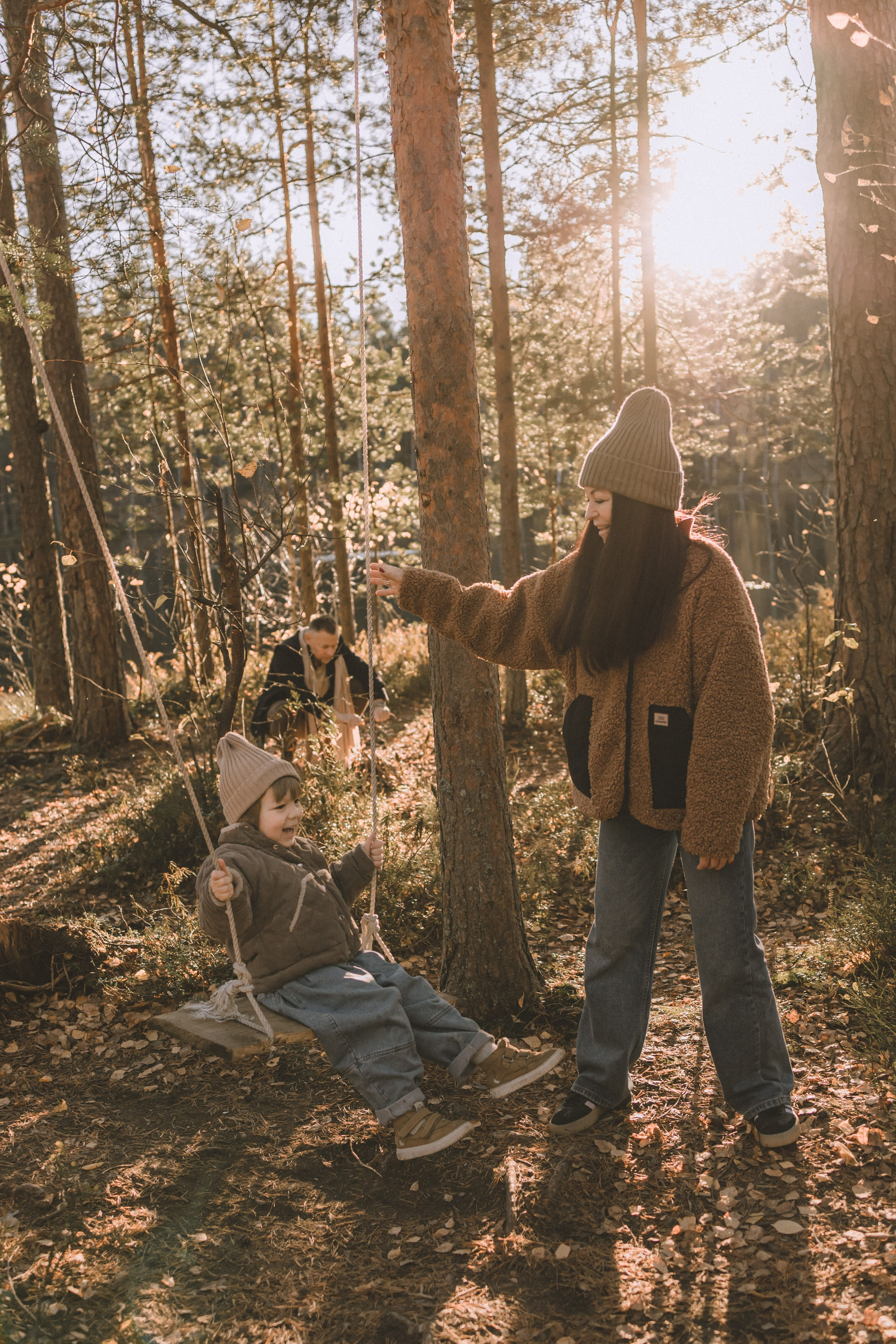 мама качает сына на качели