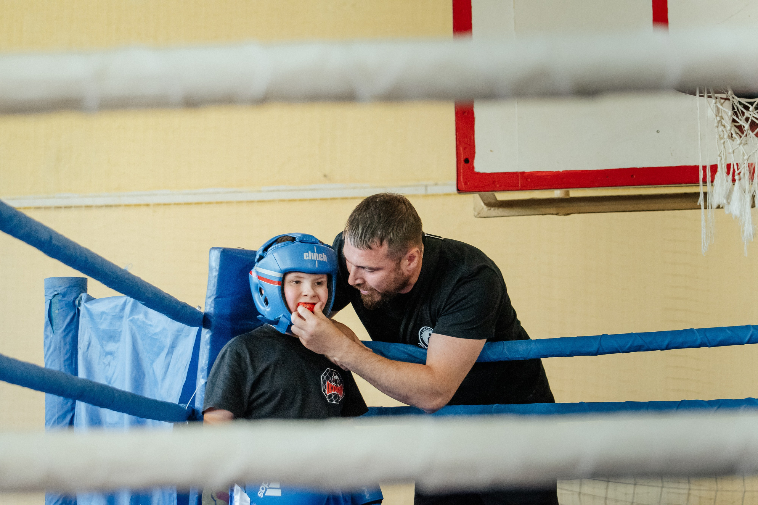 Тренер что-то говорит подопечному на ринге