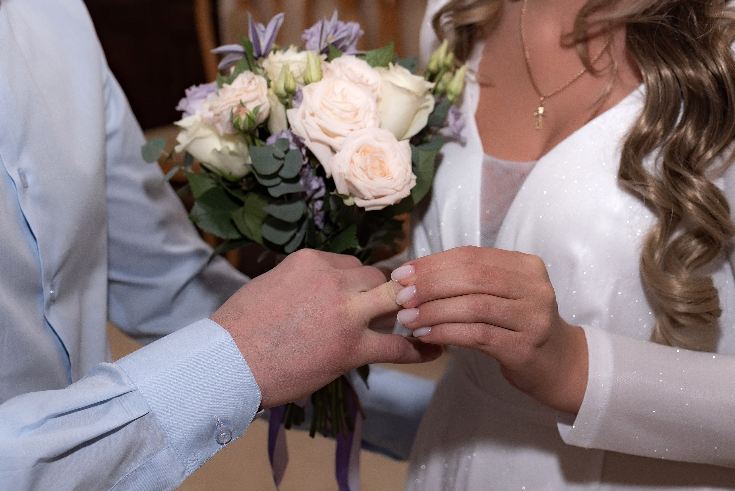 Свадебный фотограф запечатлел как жених и невеста обмениваются обручальными кольцами 