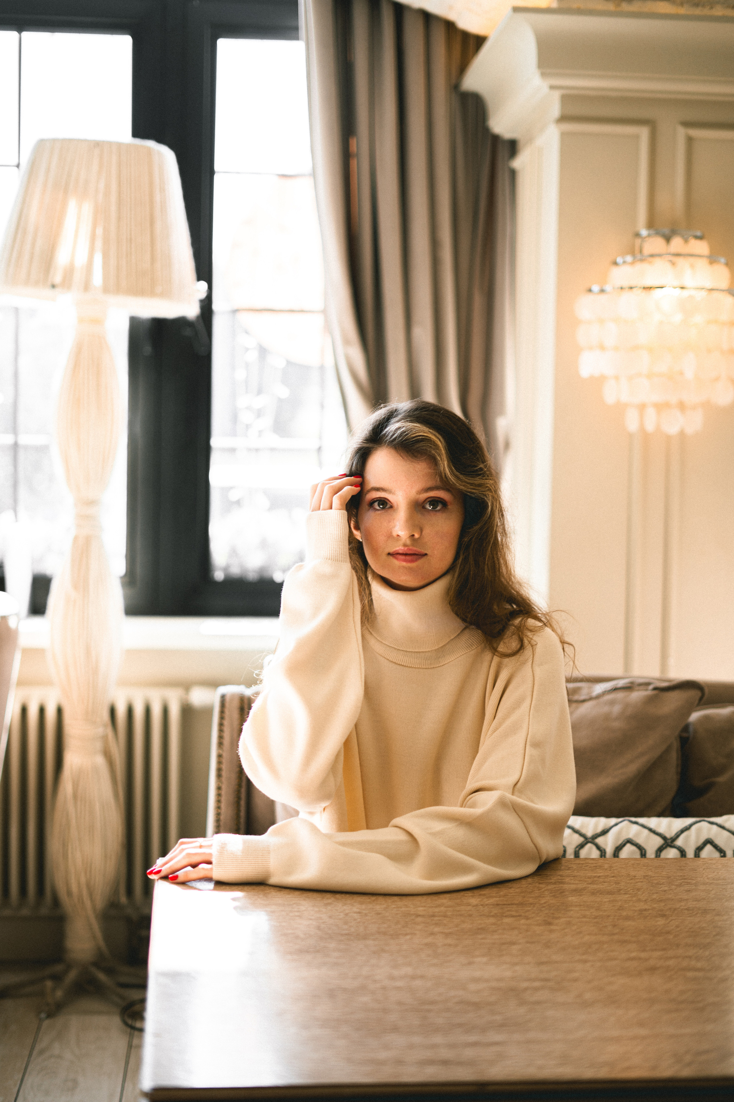 a beautiful girl in a white outfit reading a book in a cozy café