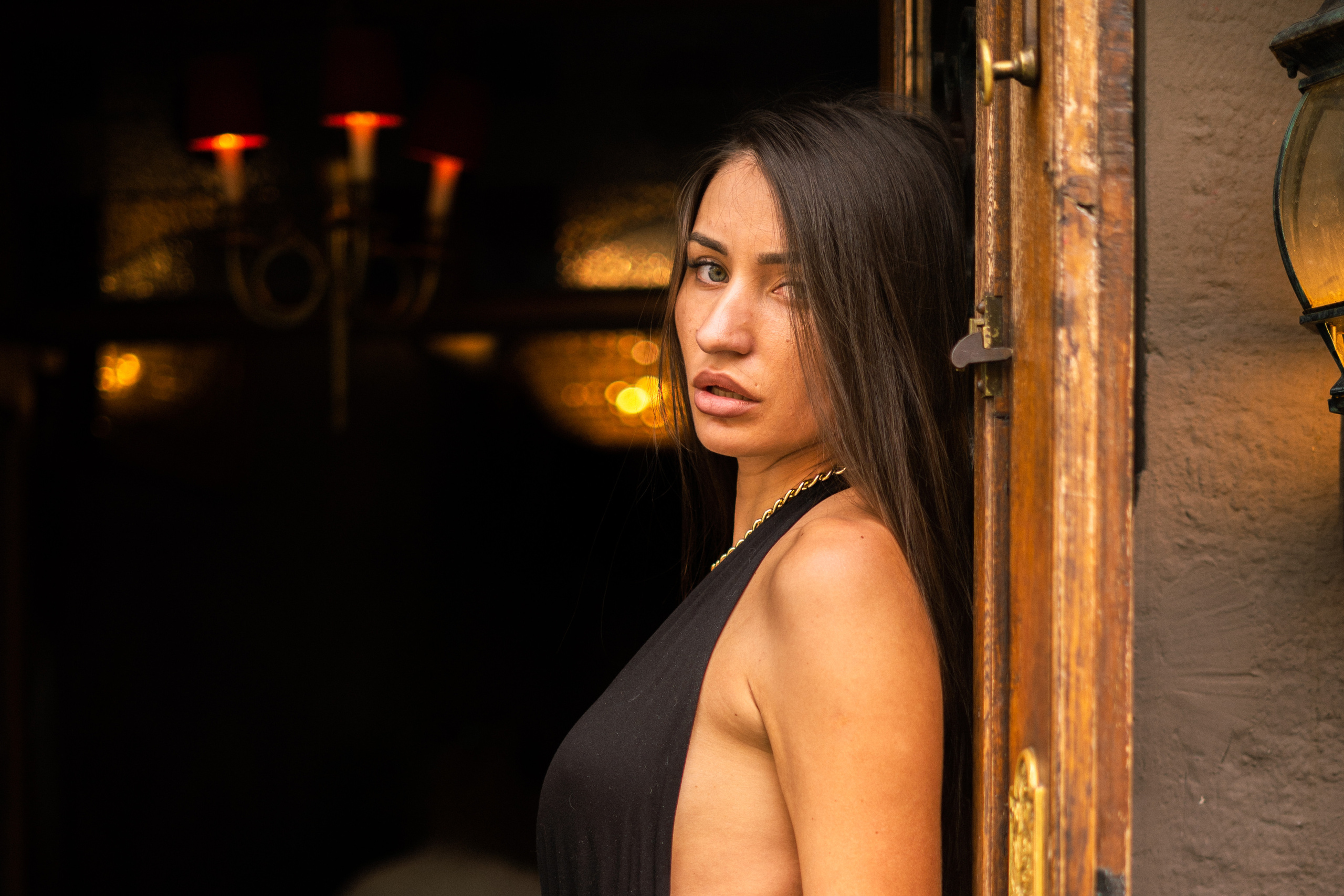 a beautiful dark-haired girl in a bright outfit against historical buildings