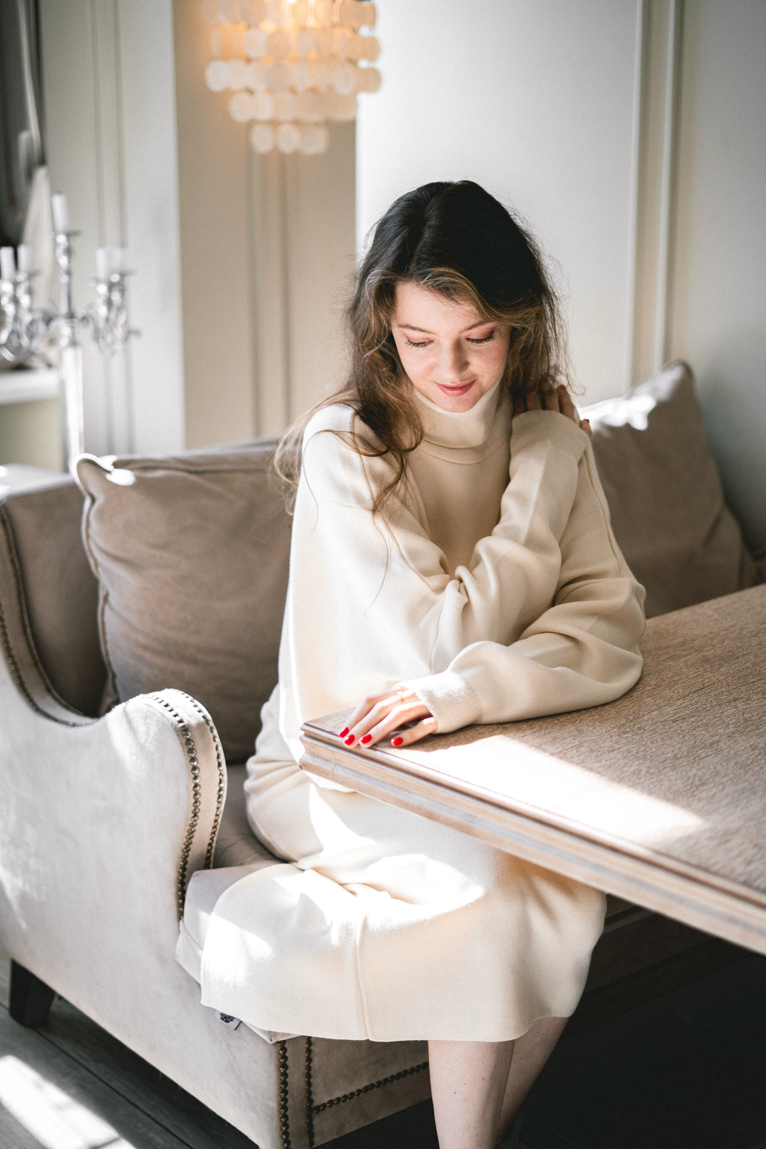 a girl in a white outfit against the soft light in a cozy café