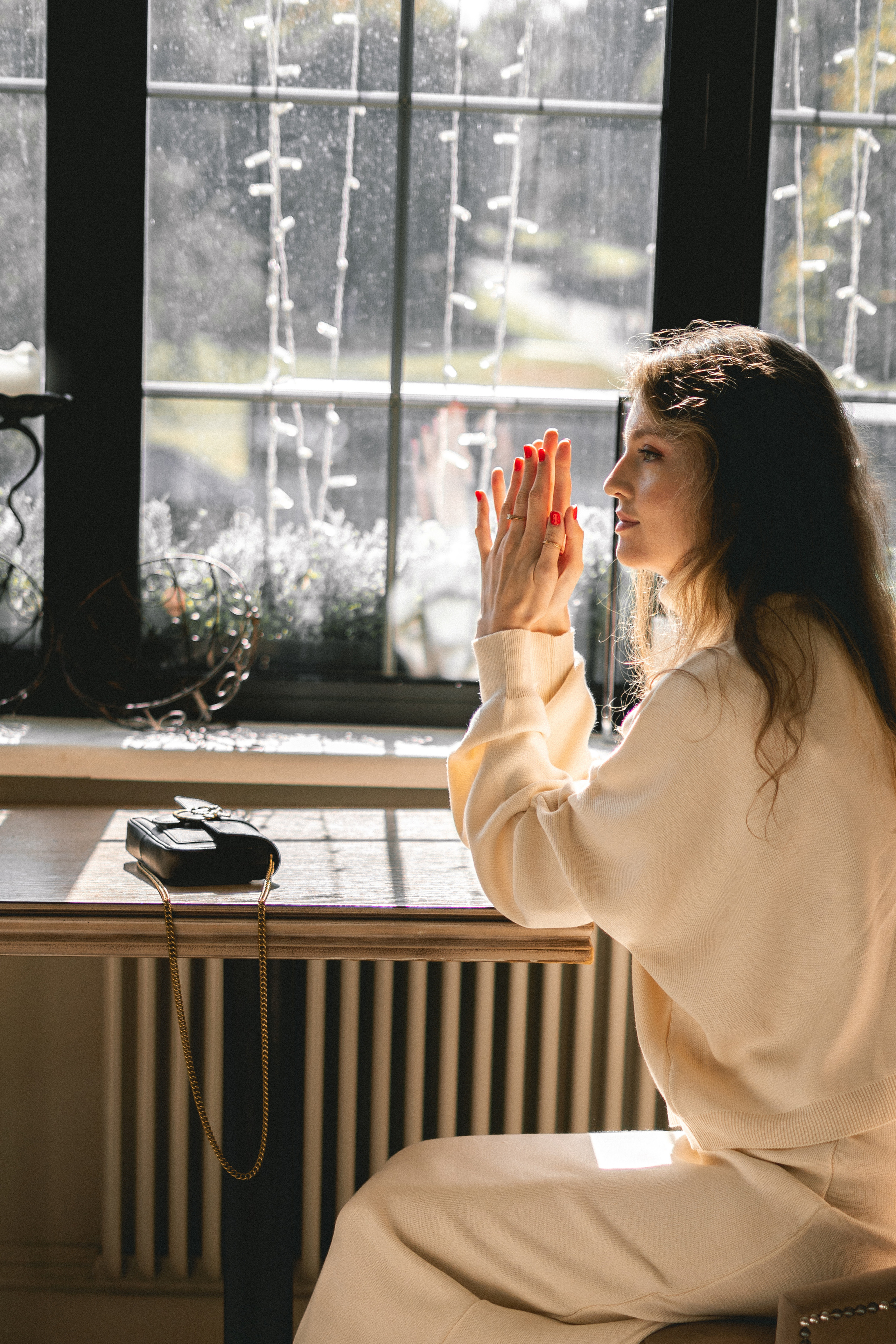 a girl in a white outfit posing at a table in a café