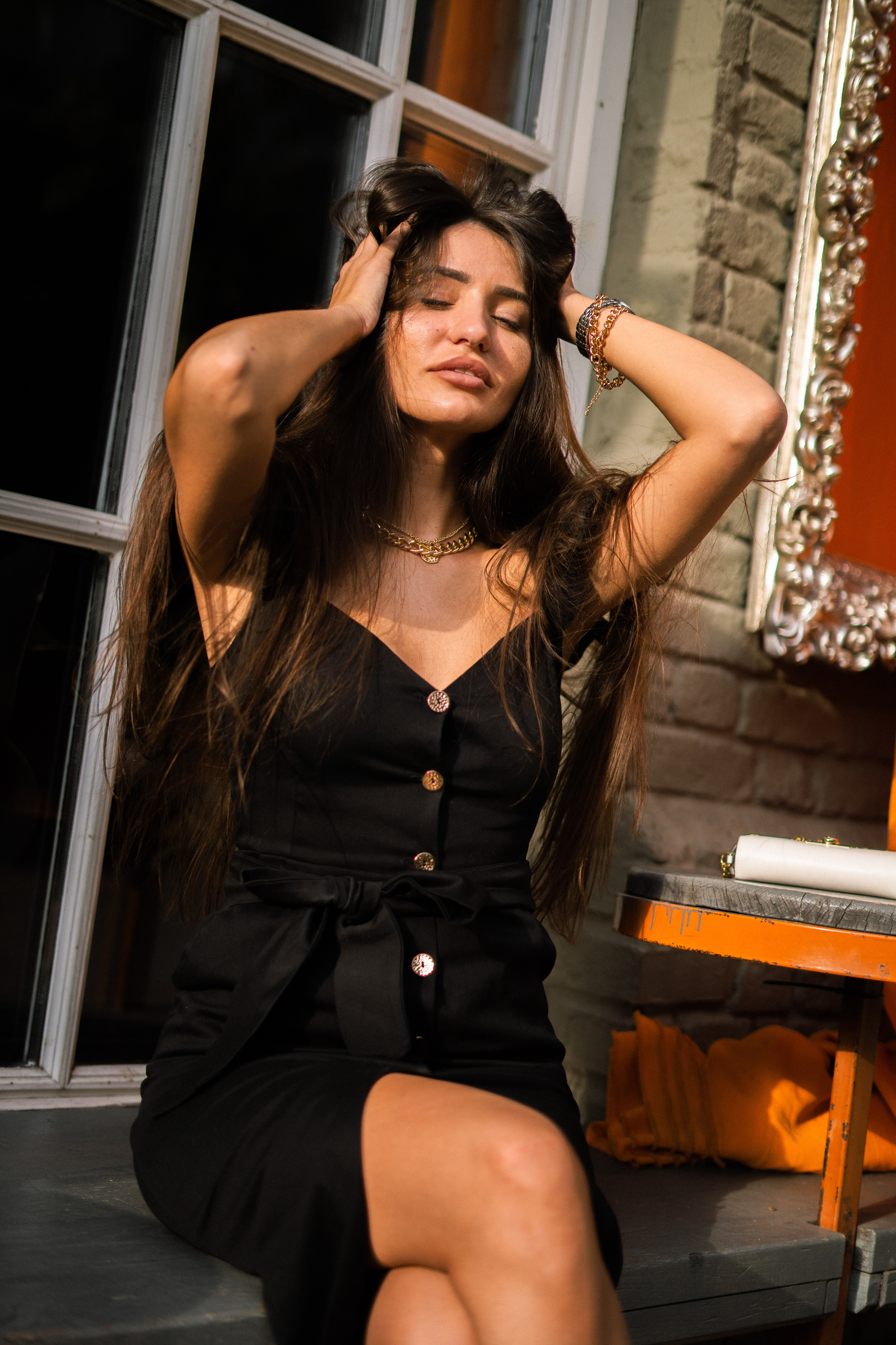 a girl in a black dress against the backdrop of evening lighting in a courtyard
