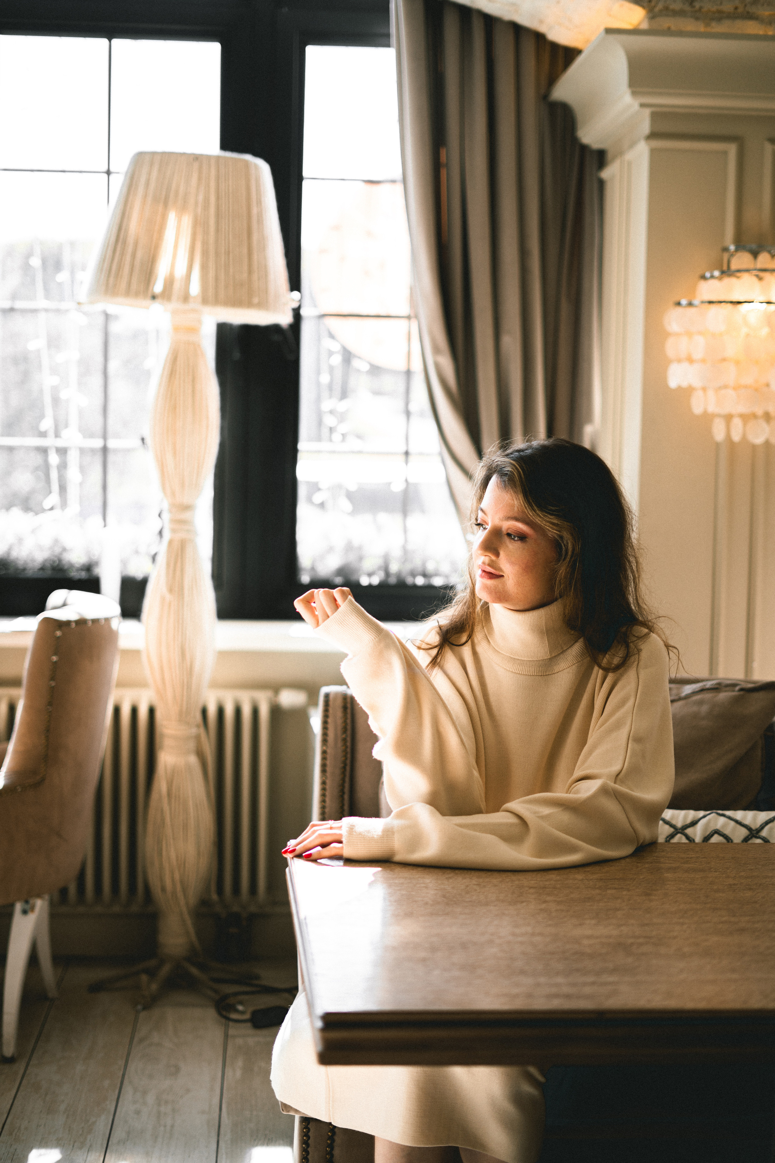 a girl in a white outfit at a table with dessert in the café