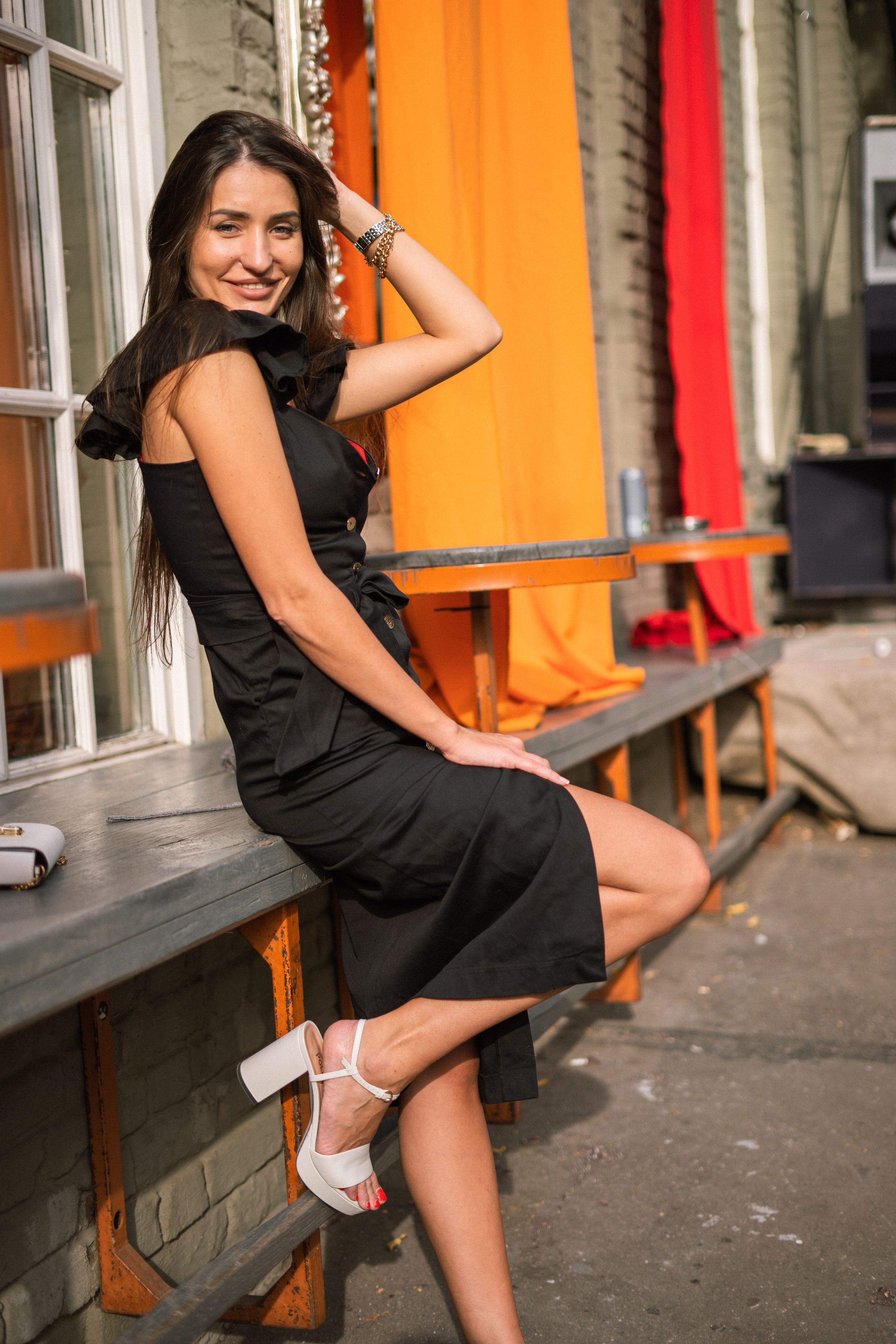 a girl in a black dress with a smile on her face in a Moscow courtyard