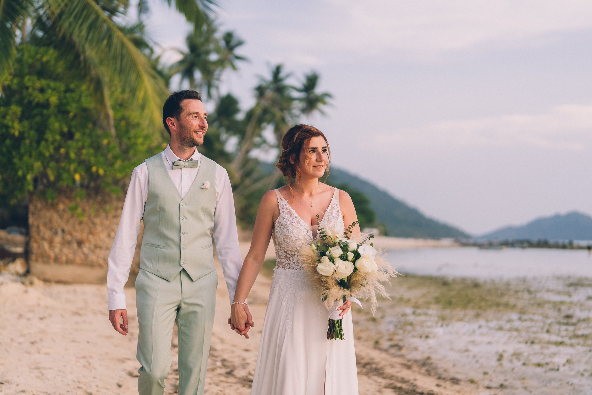 Wedding celebration with guests on a tropical sunset beach in Koh Samui