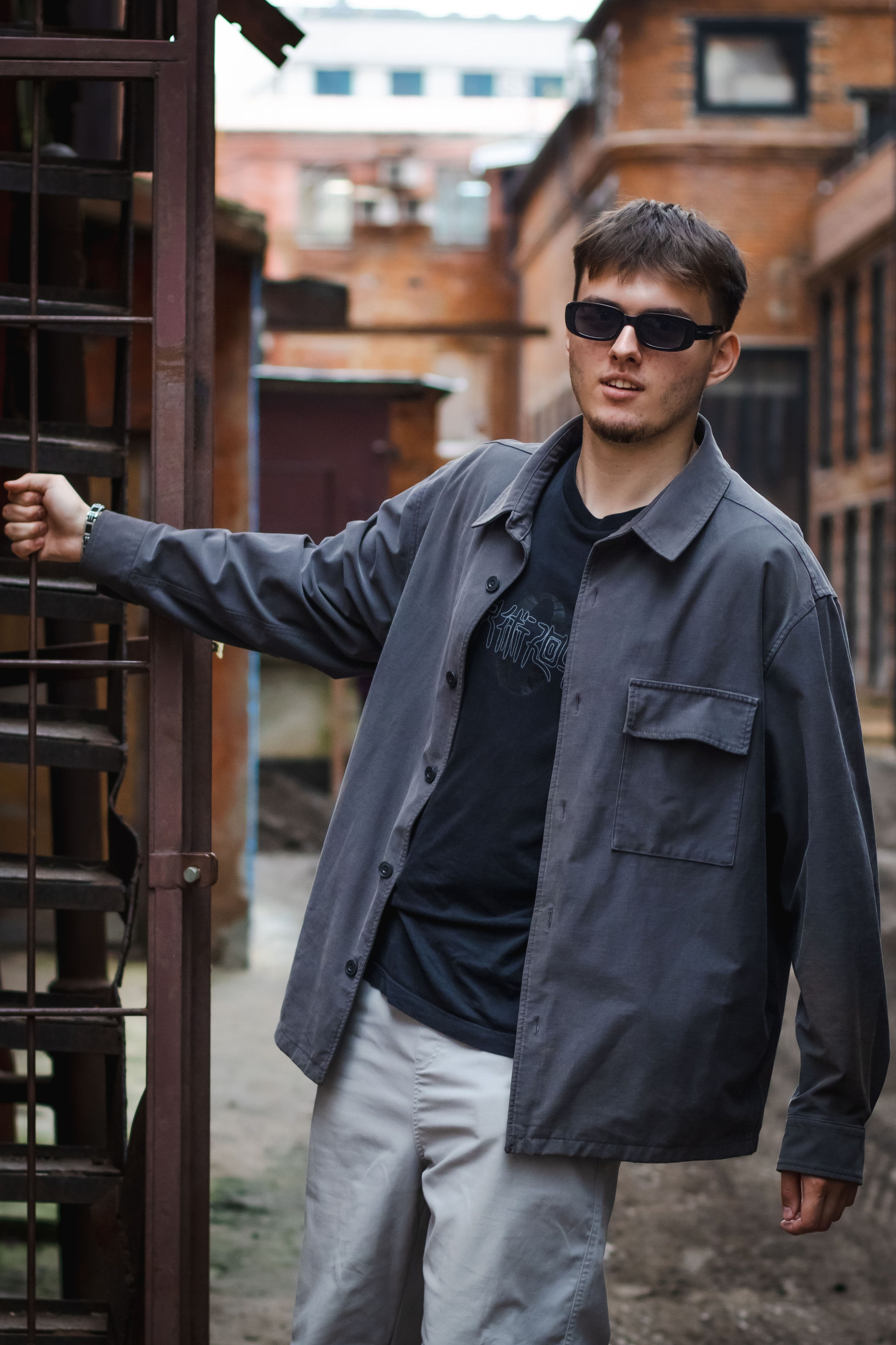 парень держится рукой за решетку 