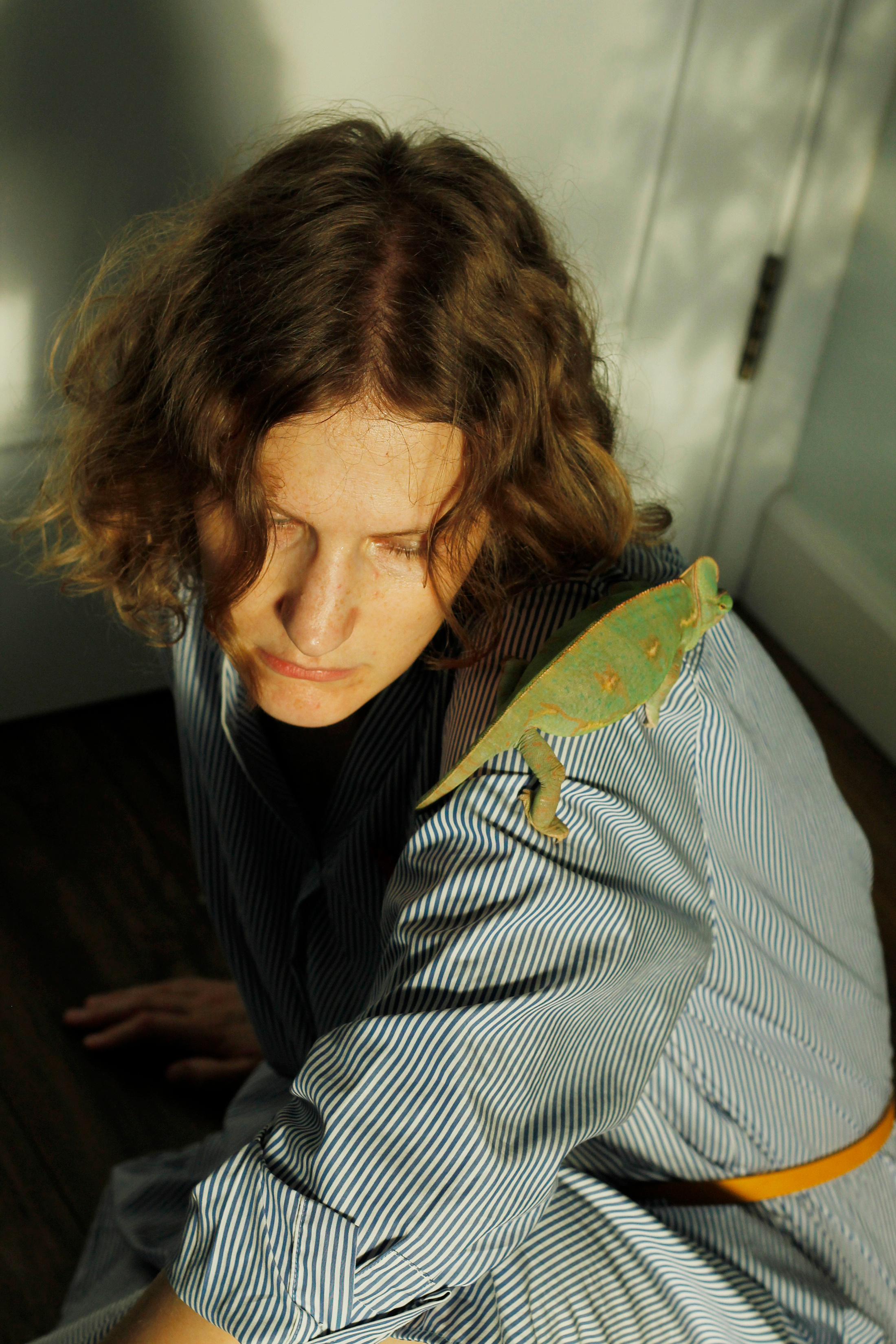 Woman with a chameleon sitting on the floor