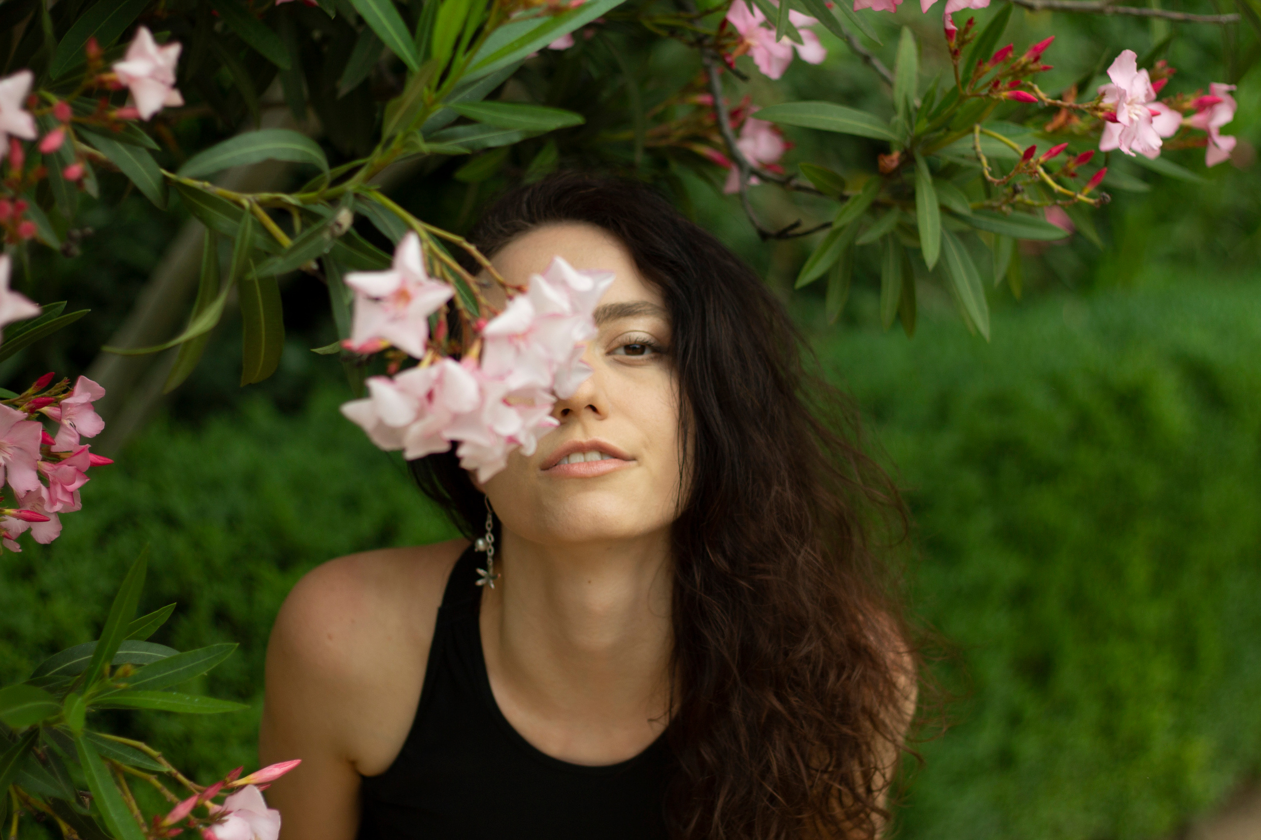 Photo of woman in the tropic forest whit a flower on her eye