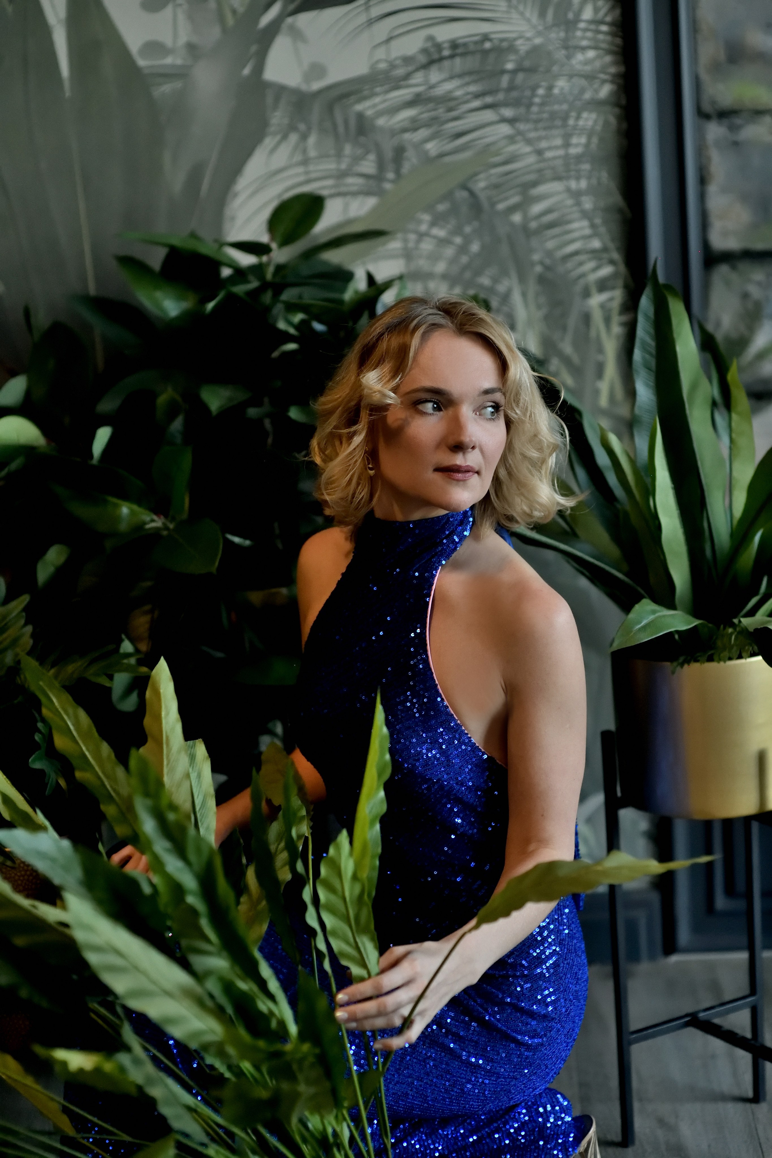 Портрет девушки в синем вечернем платье на фоне зелени.