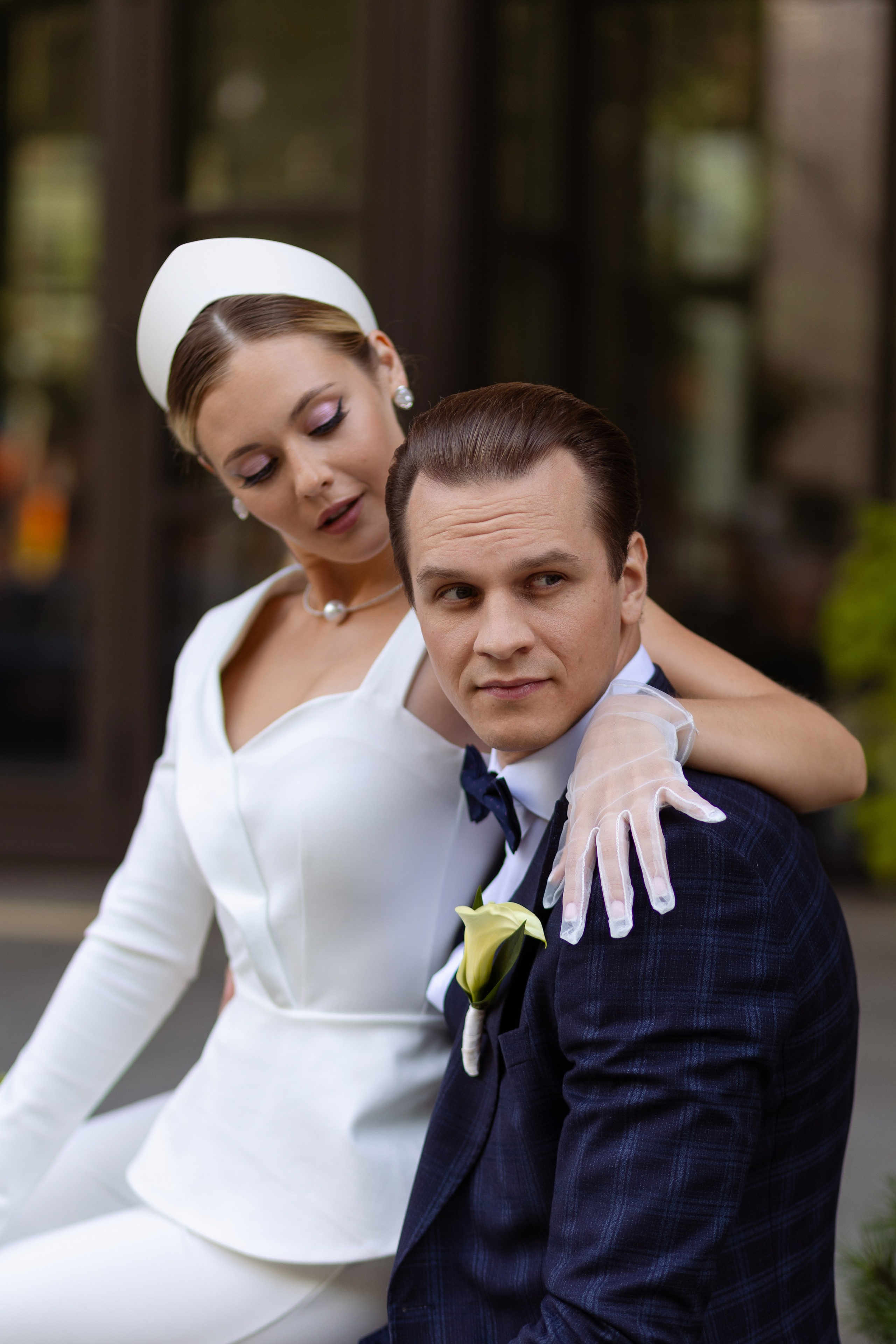 Невеста обняла жениха и смотрит на него.