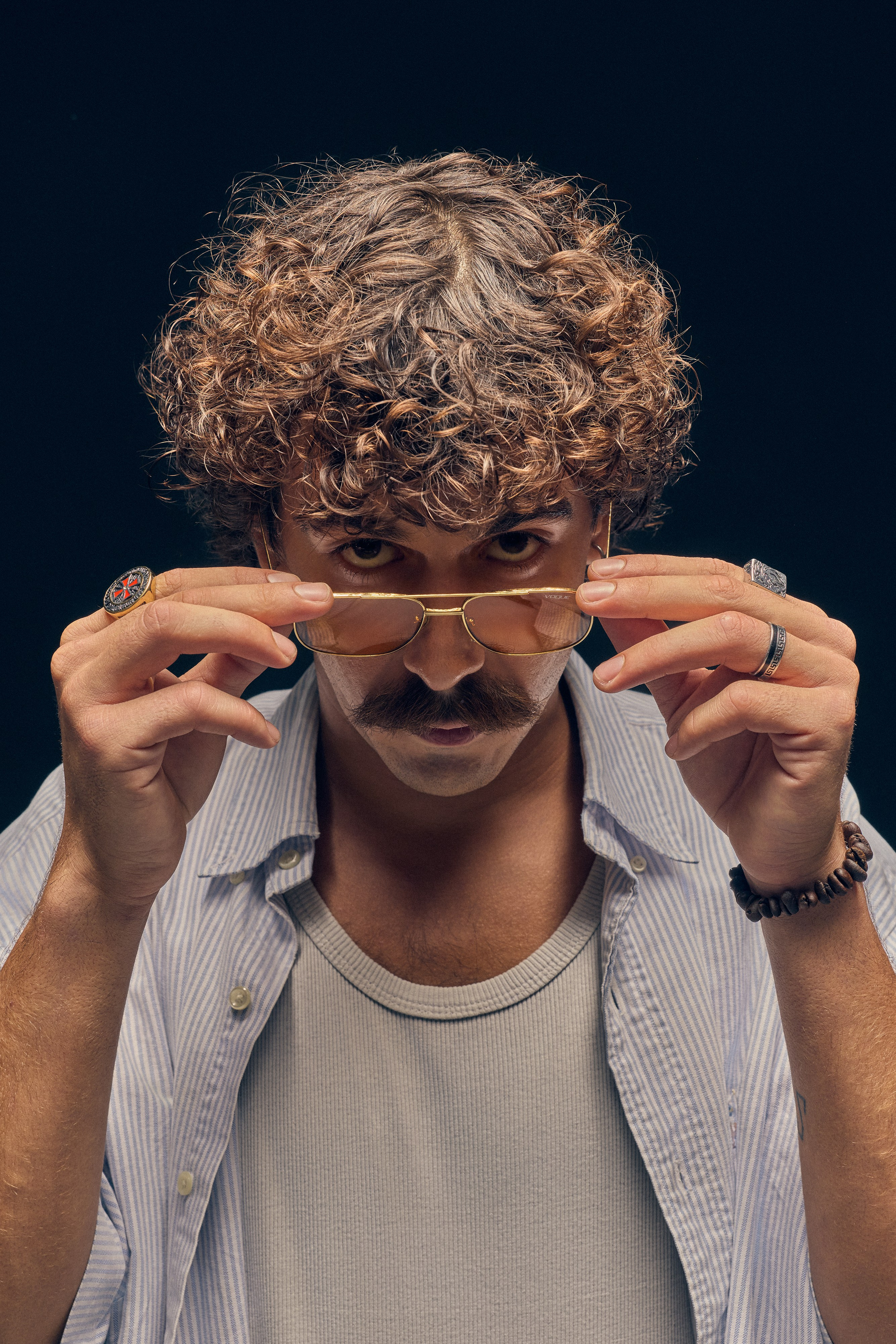 Vintage portrait of curly haired man wearing sunglasses holding a tray of flour