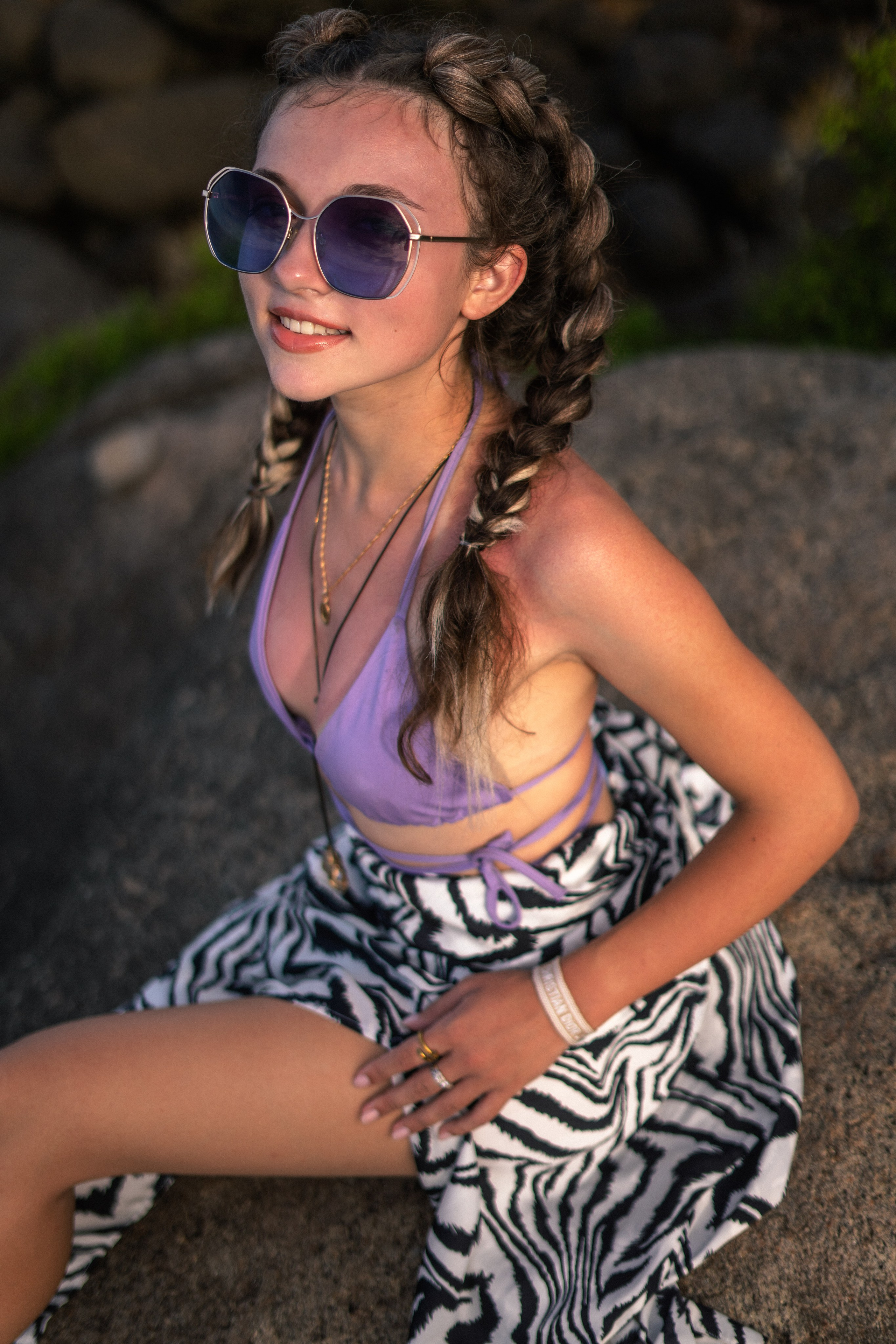 a young beauty in a purple swimsuit against the backdrop of ocean waves