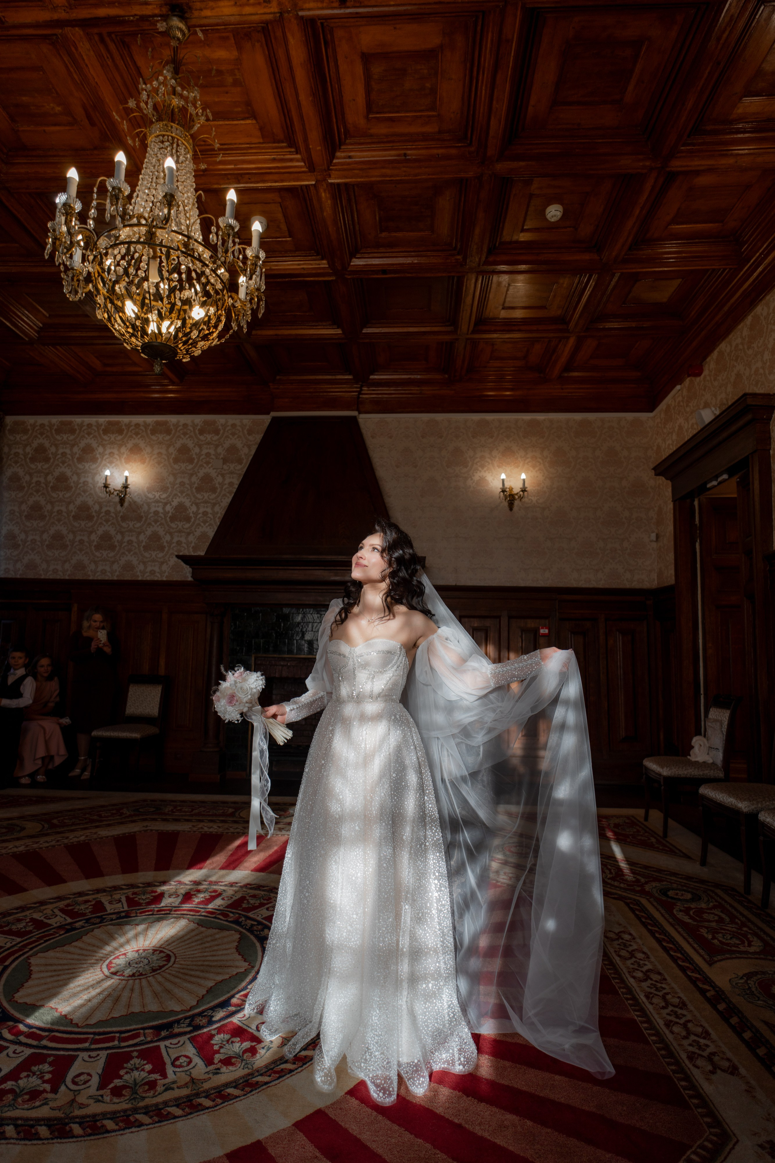 Невеста стоит в лучах солнца в главном зале в загсе на петроградке