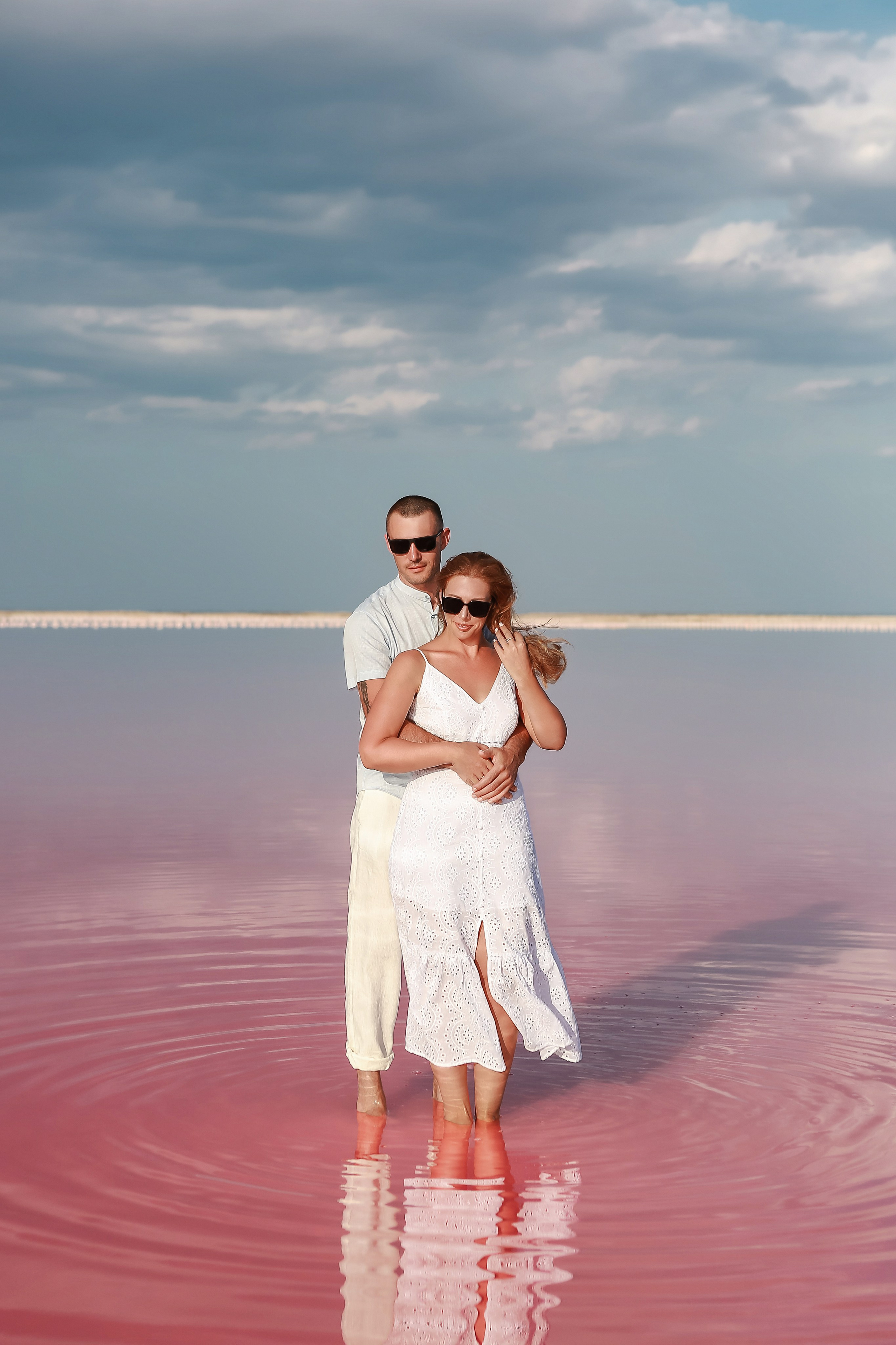 парень с девушкой стоят на фоне розового озера в Евпатории