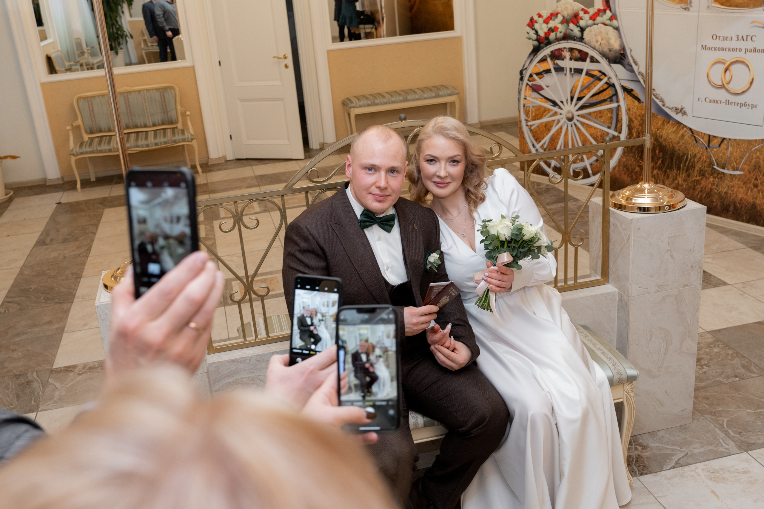 жених и невеста позируют в загсе московского района