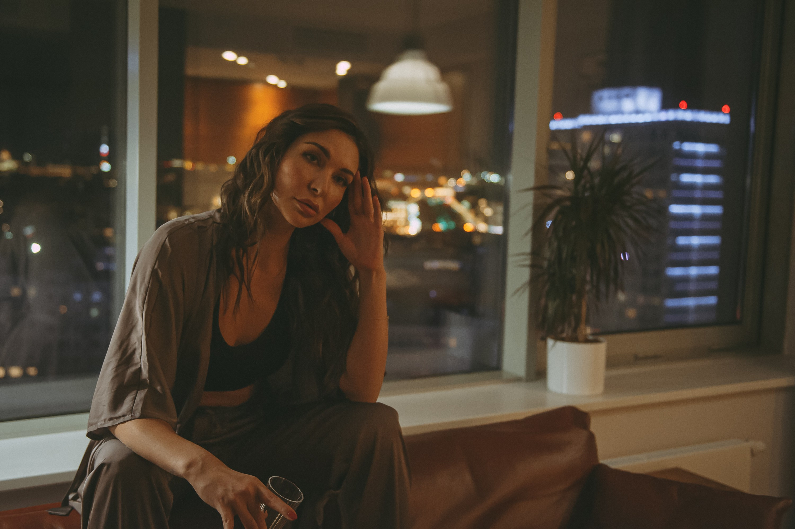 девушка у окна на фоне ночного города