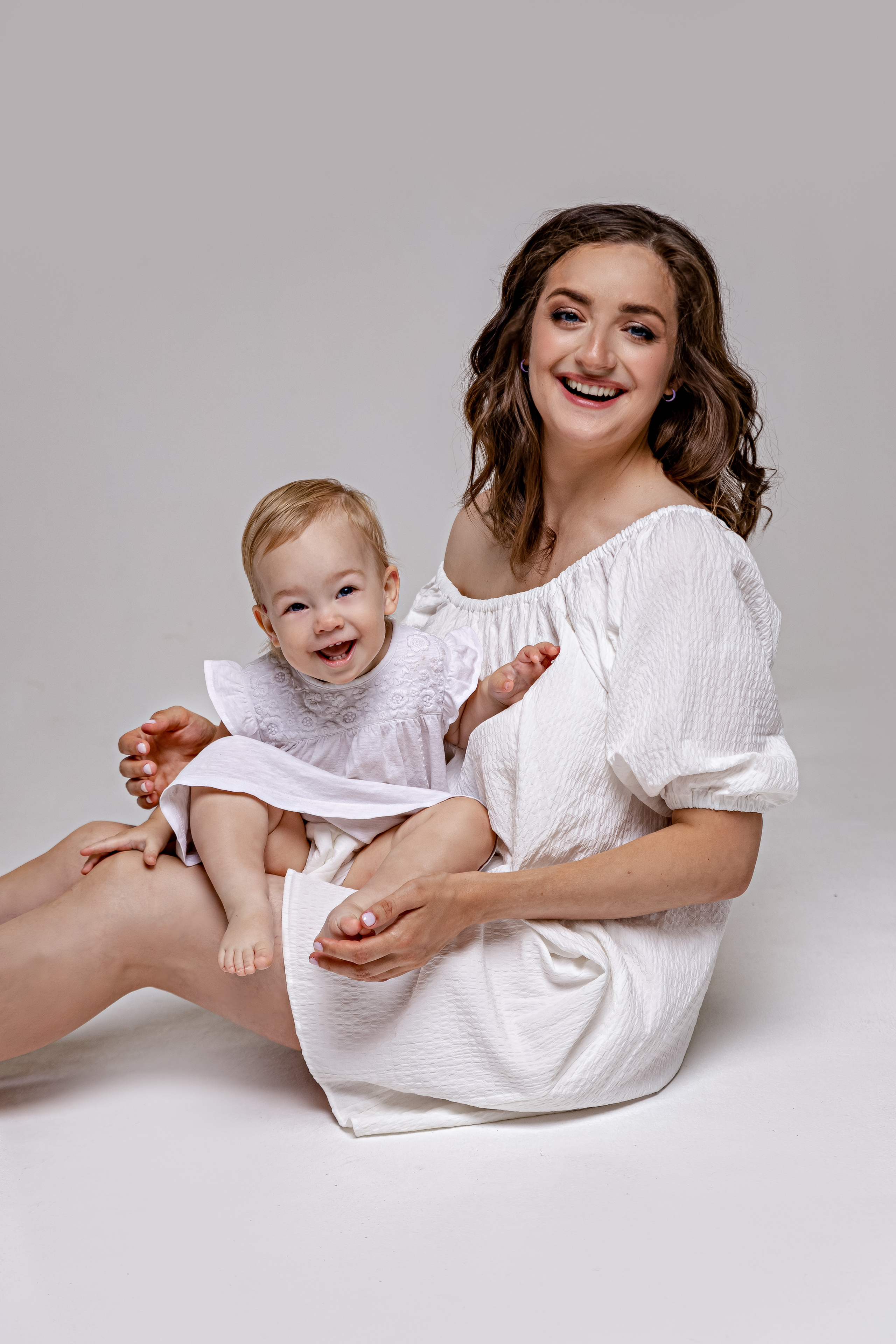Мама и малышка на белом фоне в белой одежде 