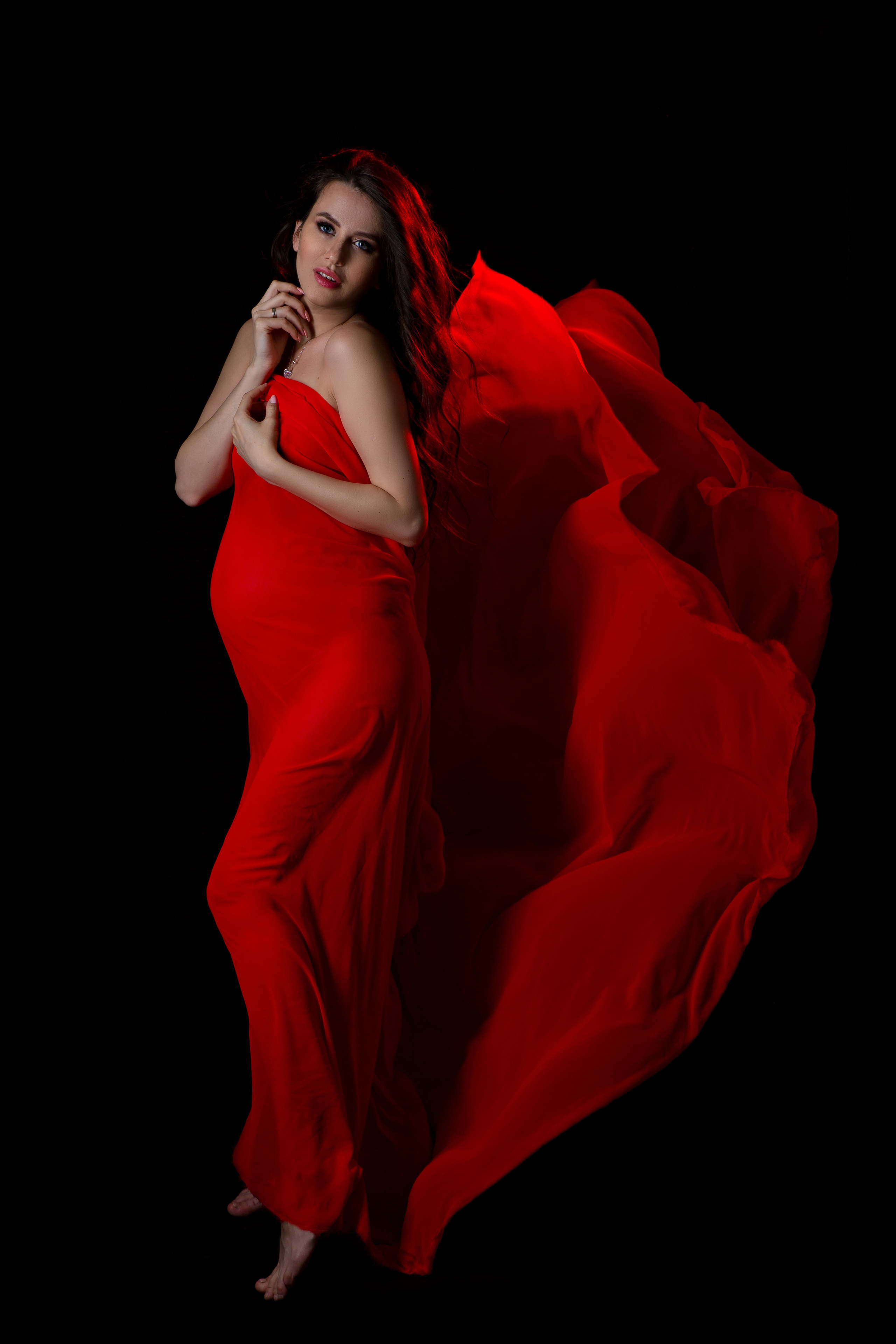 беременная и летящая красная ткань 