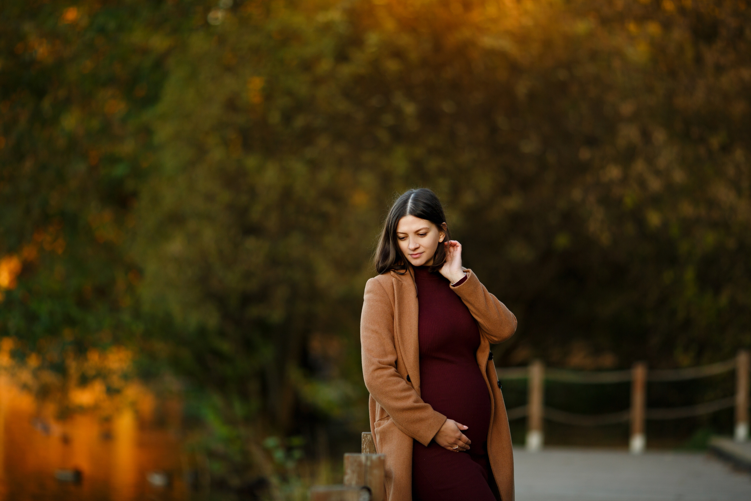 Беременная в осеннем пейзаже в парке на улице 