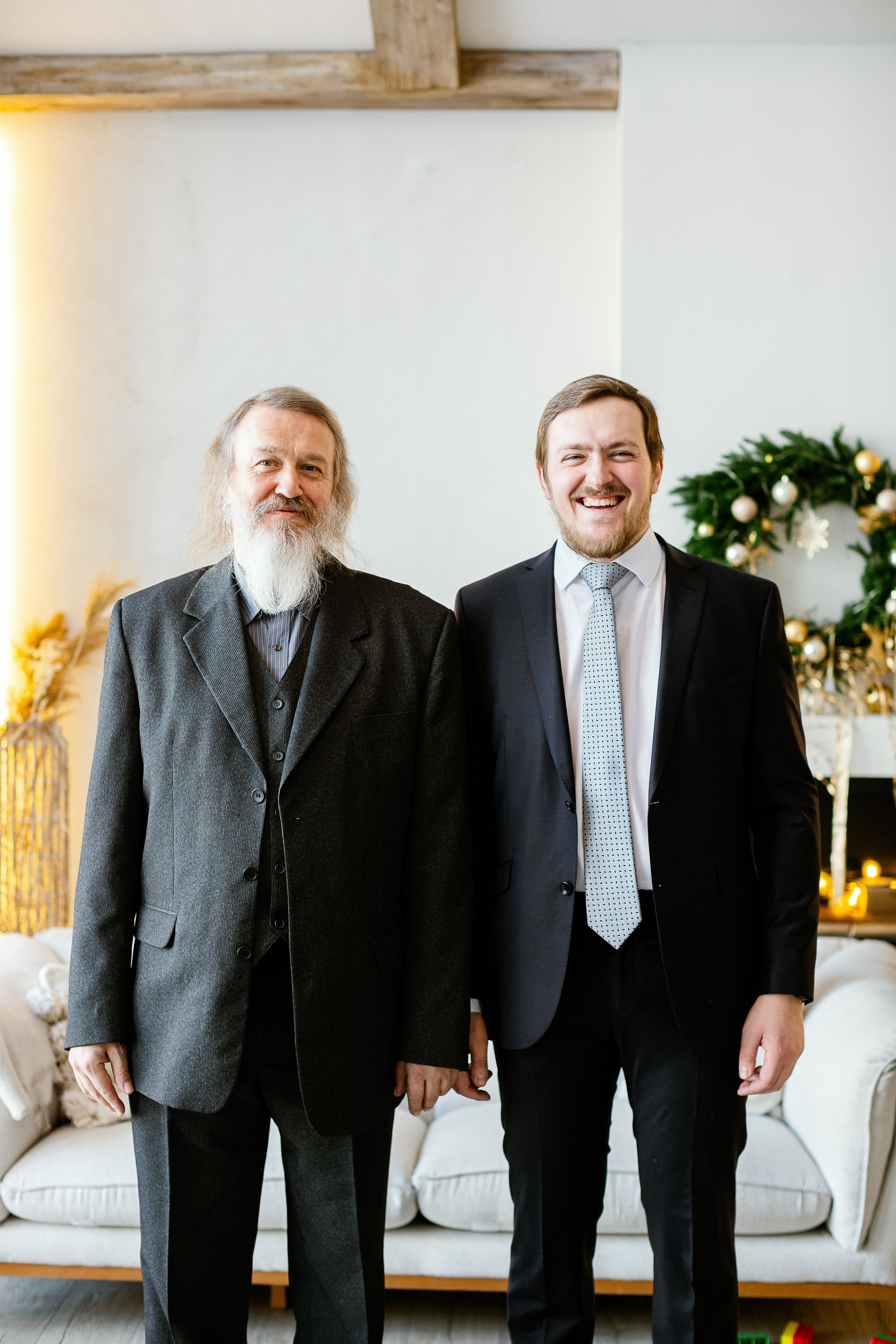 Отец с сыном в праздничной фотостудии стоят.