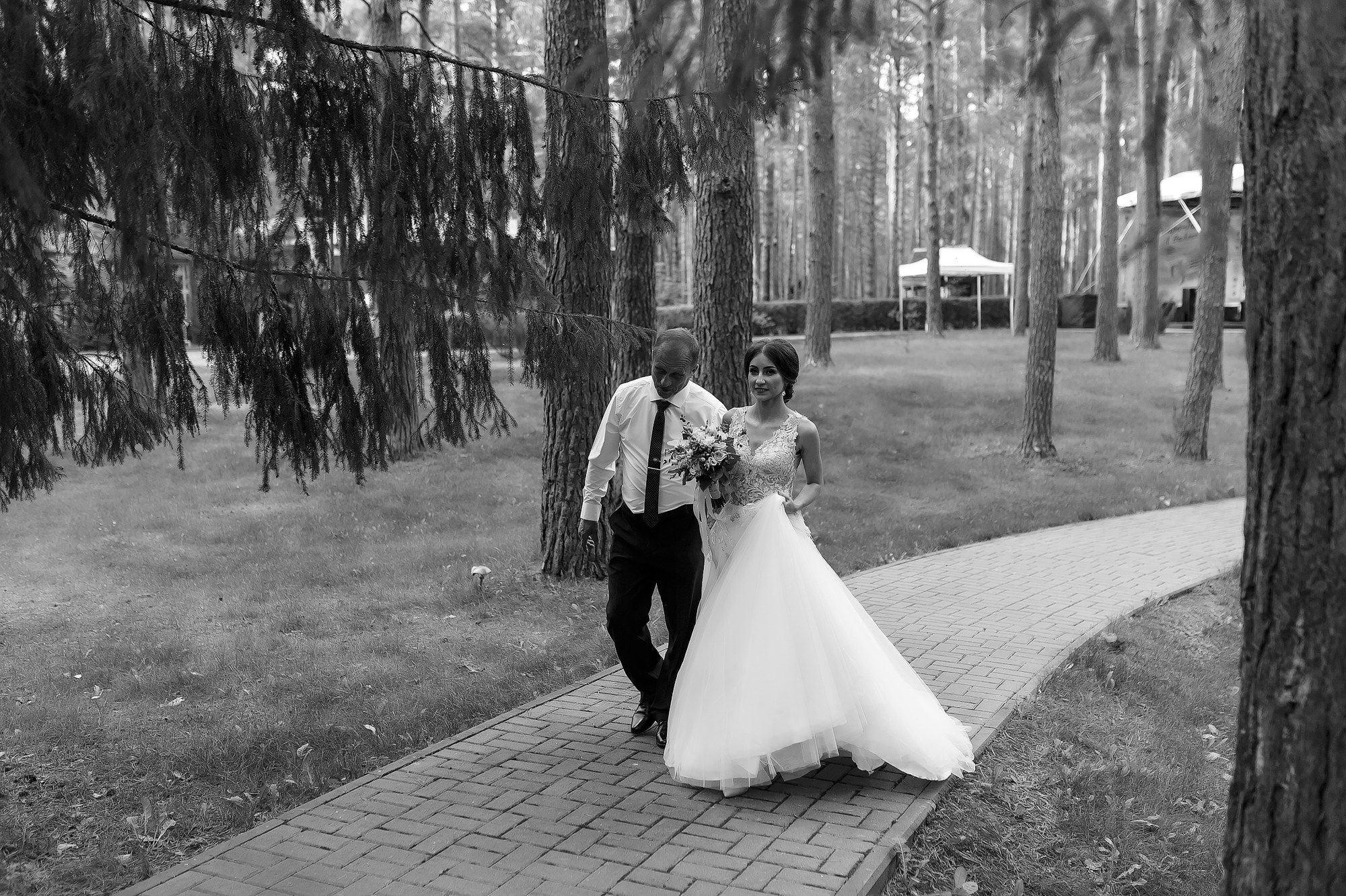 Отец ведет невесту к алтарю на церемонию выездной регистрации в отеле