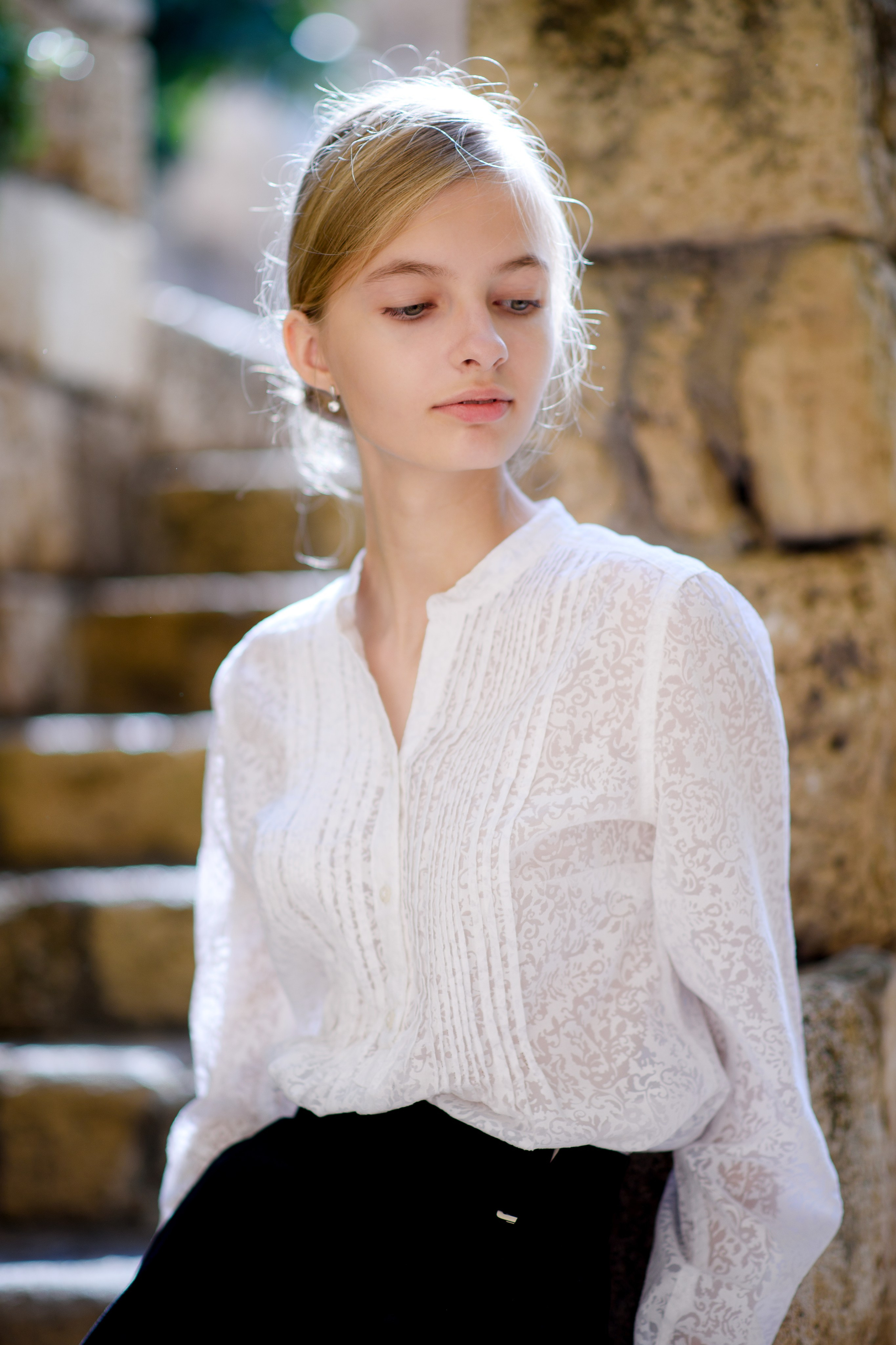 Девочка подросток на фоне лестницы в контровом свете крупный план