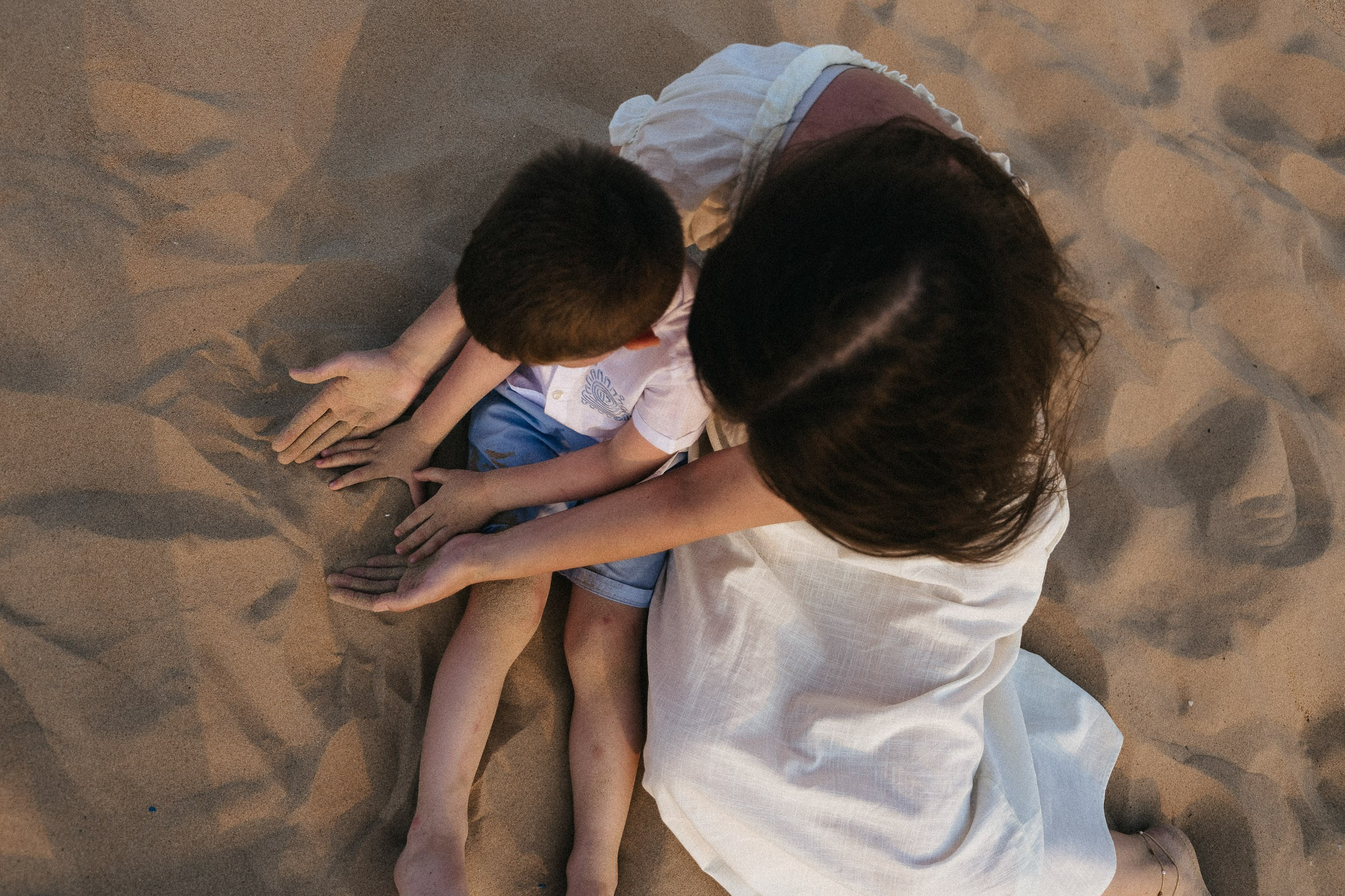 мама и ребенок играют на песке