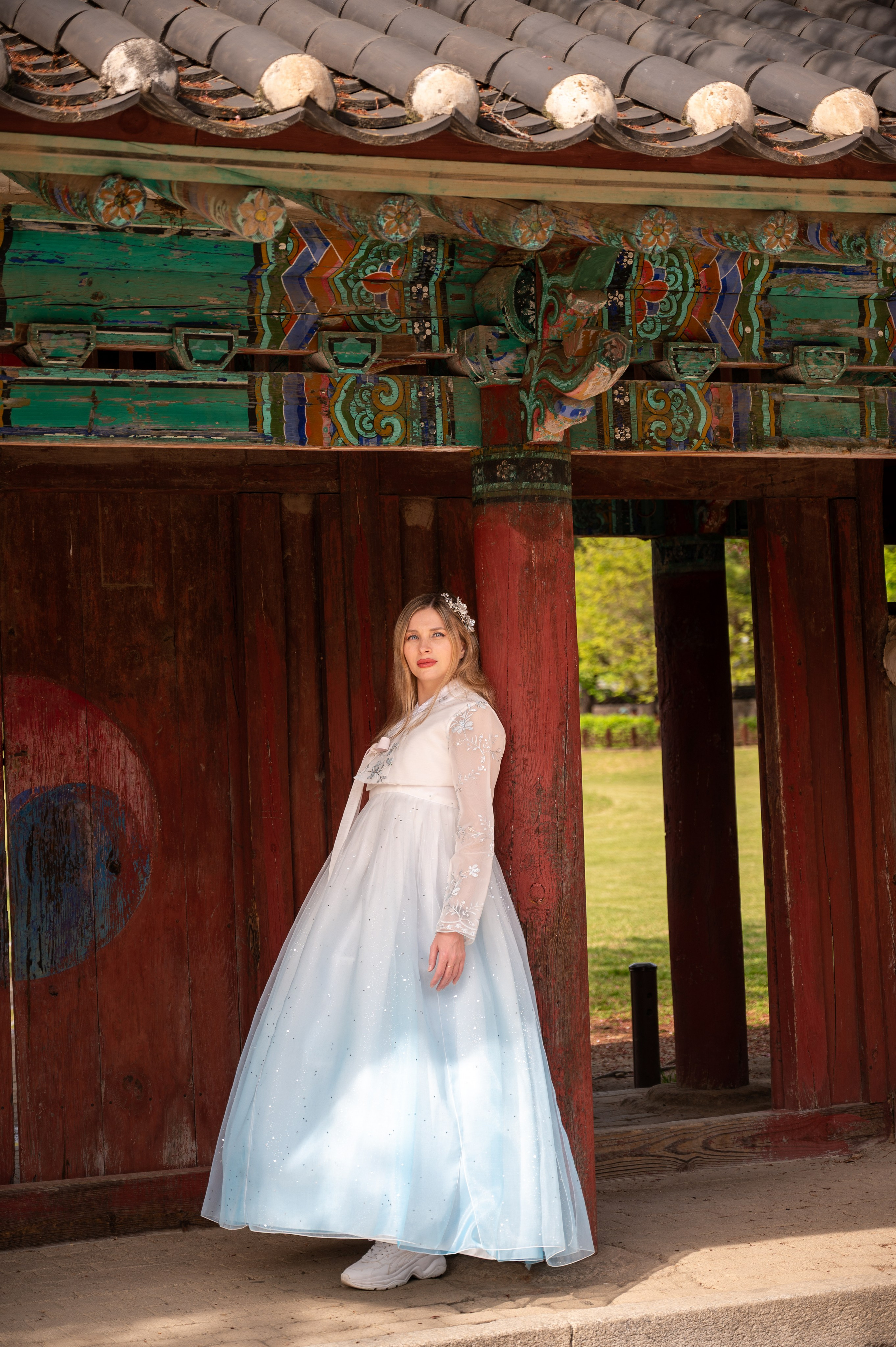 Woman in a light blue hanbok by traditional Korean gates — hanbok photoshoot in Busan · 釜山 韓服撮影