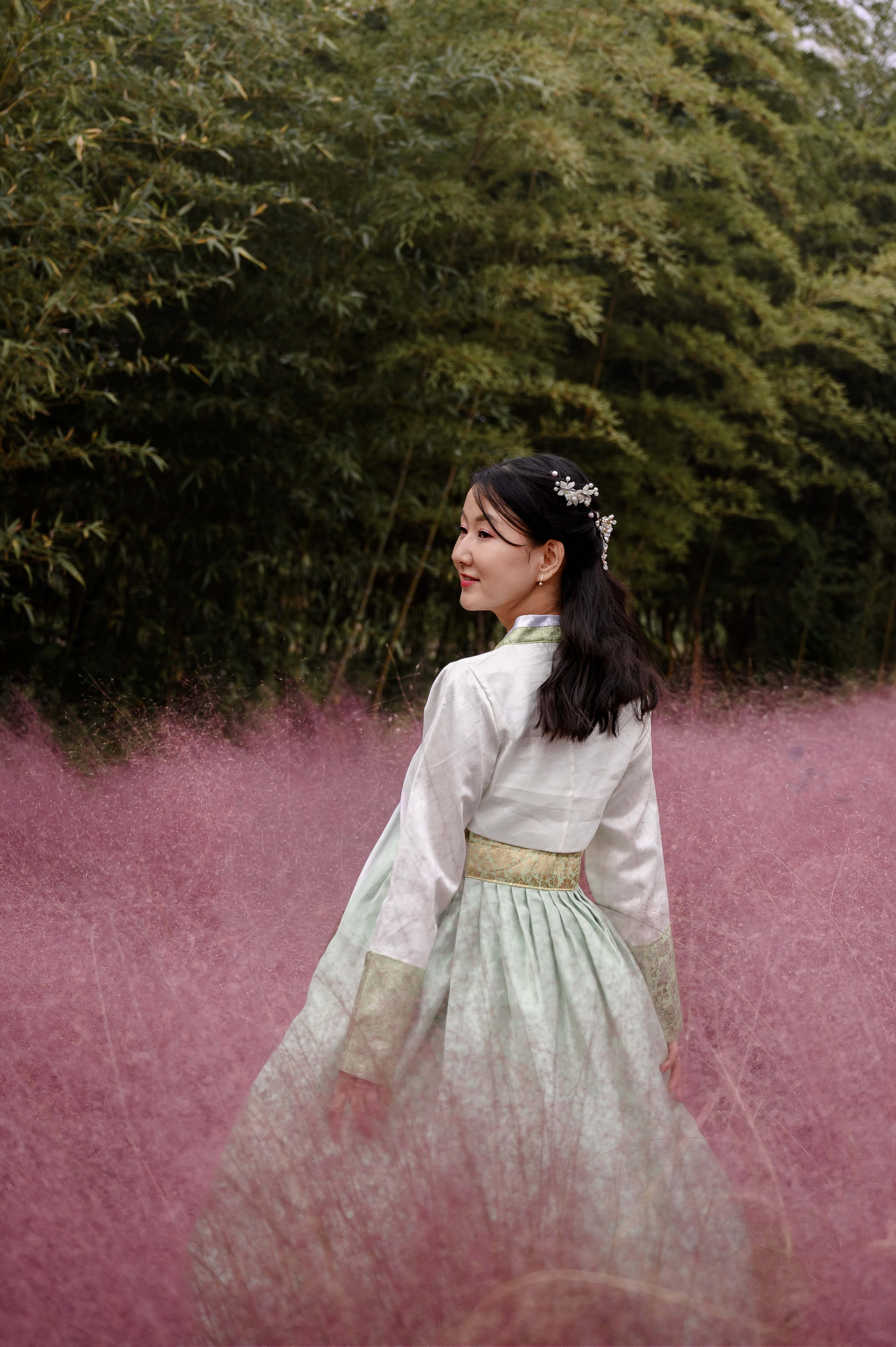 Woman in a mint hanbok in pink grass against bamboo, Daejeo Ecological Park, Busan · 감천문화마을