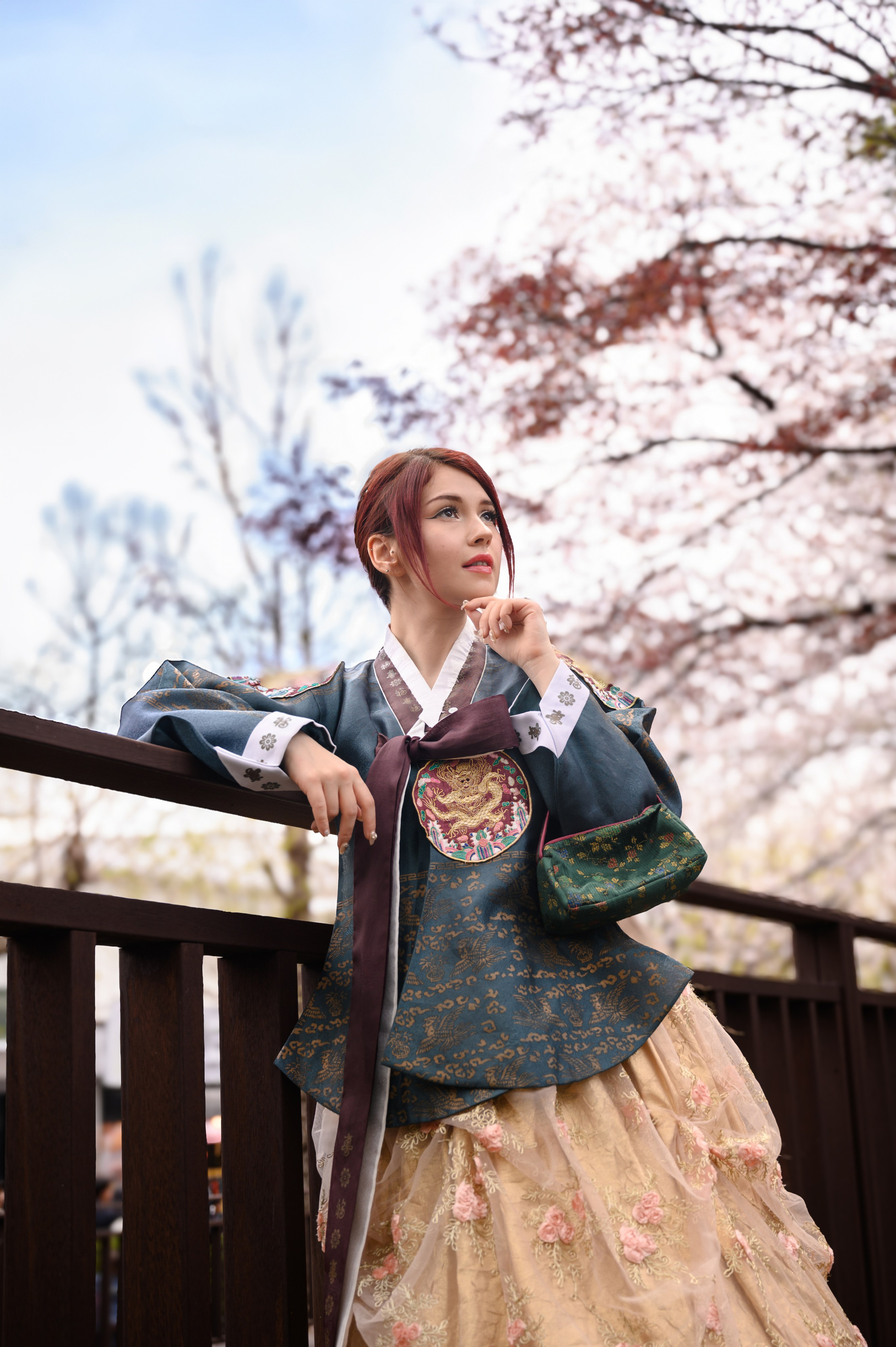 Woman in hanbok by wooden railings under cherry blossoms — hanbok photoshoot in Busan · 釜山 韓服撮影