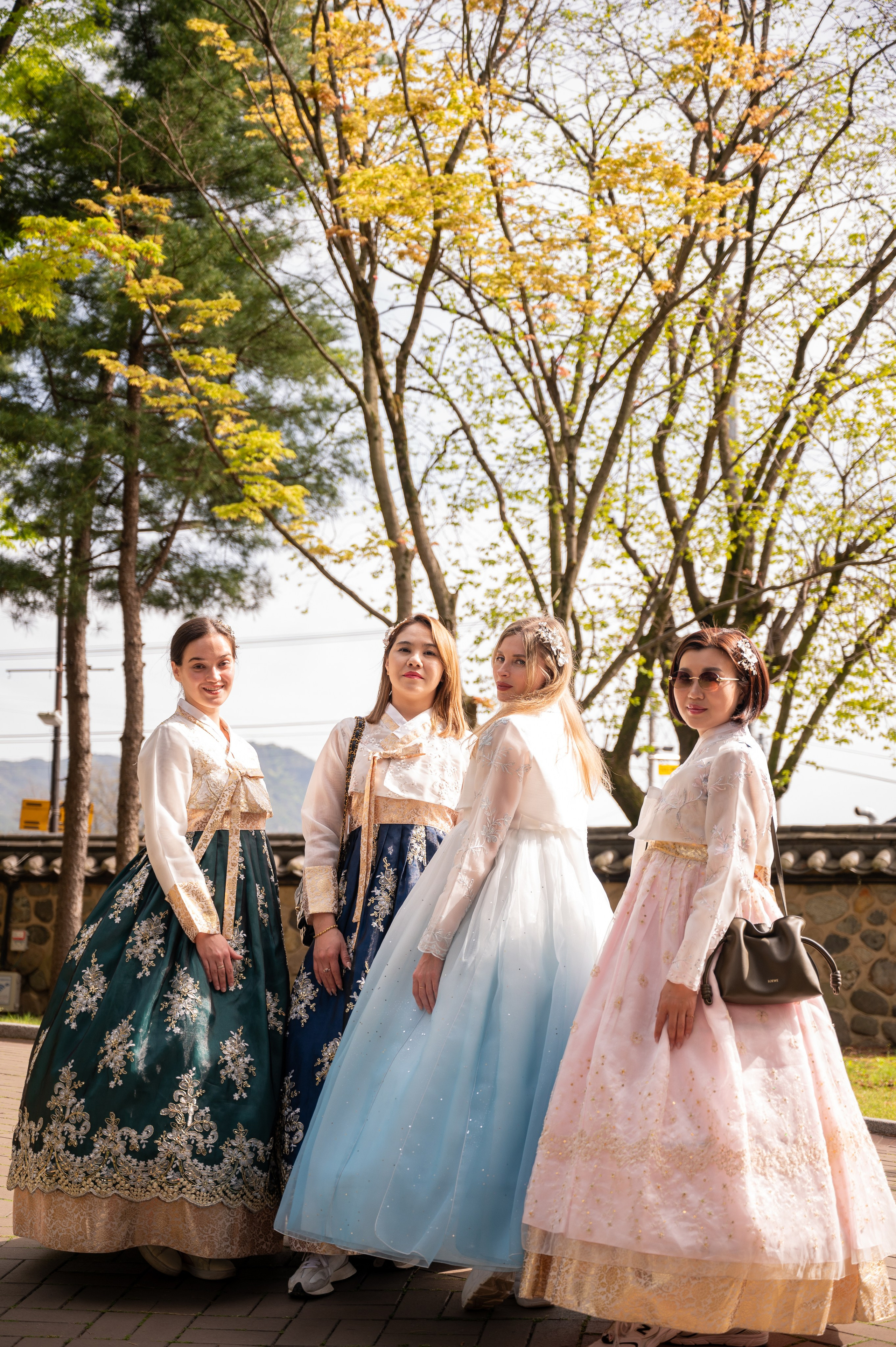 Three friends in hanbok among autumn trees — hanbok photoshoot in Busan · 부산 한복 스냅