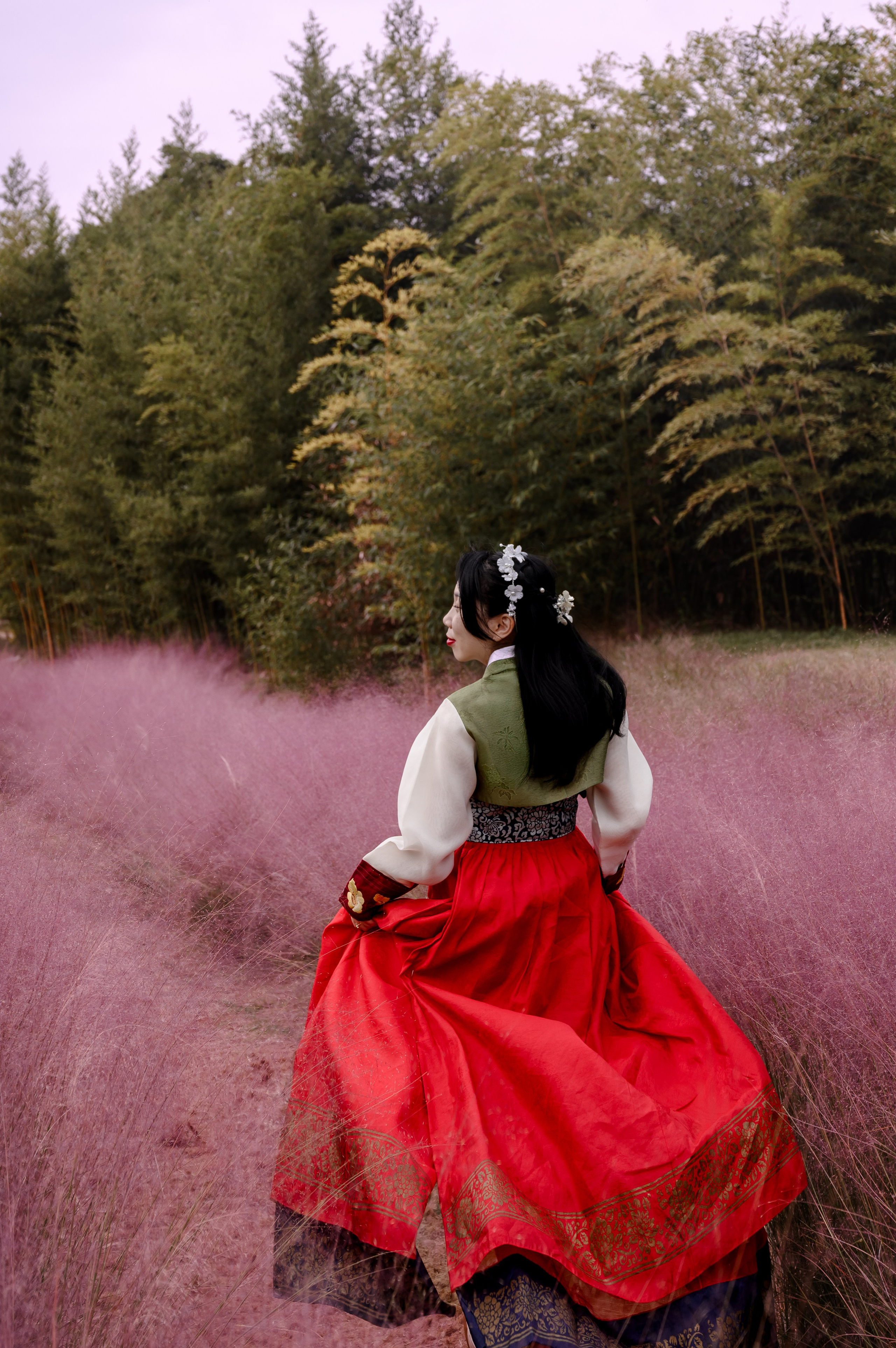 Woman in a red hanbok among pink grass and bamboo, Daejeo Ecological Park, Busan · 부산 한복 스냅