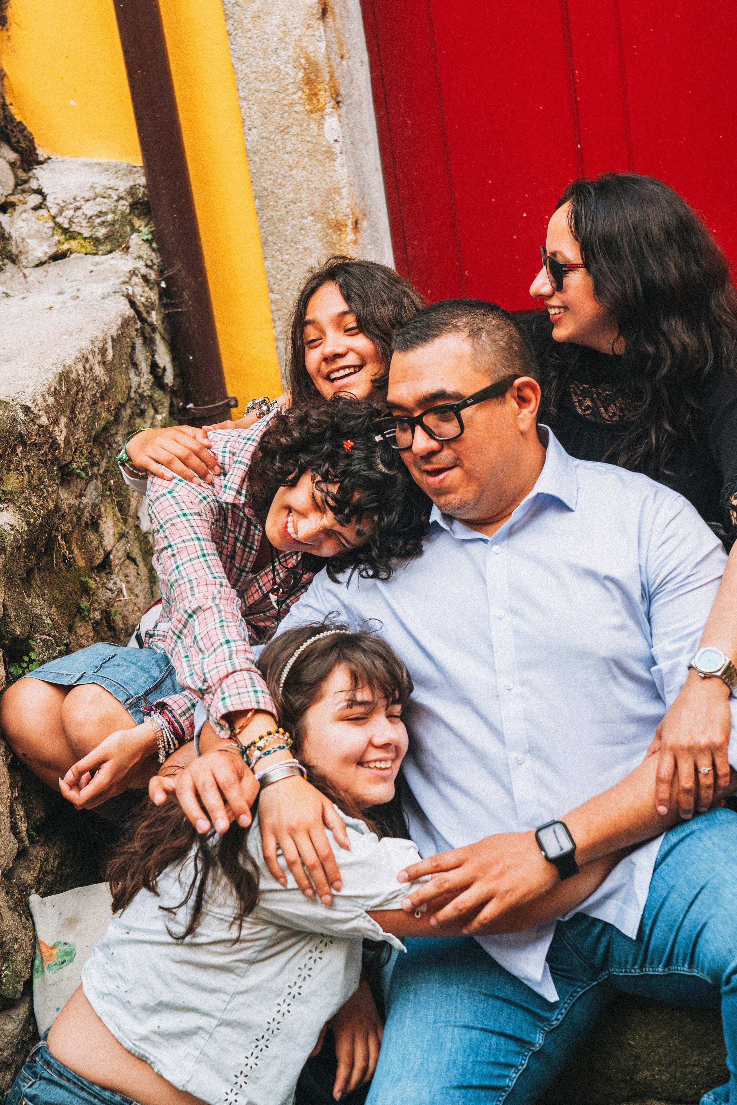 Группа людей семья влюбленные гуляет по живописной узкой улочке в Португалии, окружённой старыми домами и зеленью.