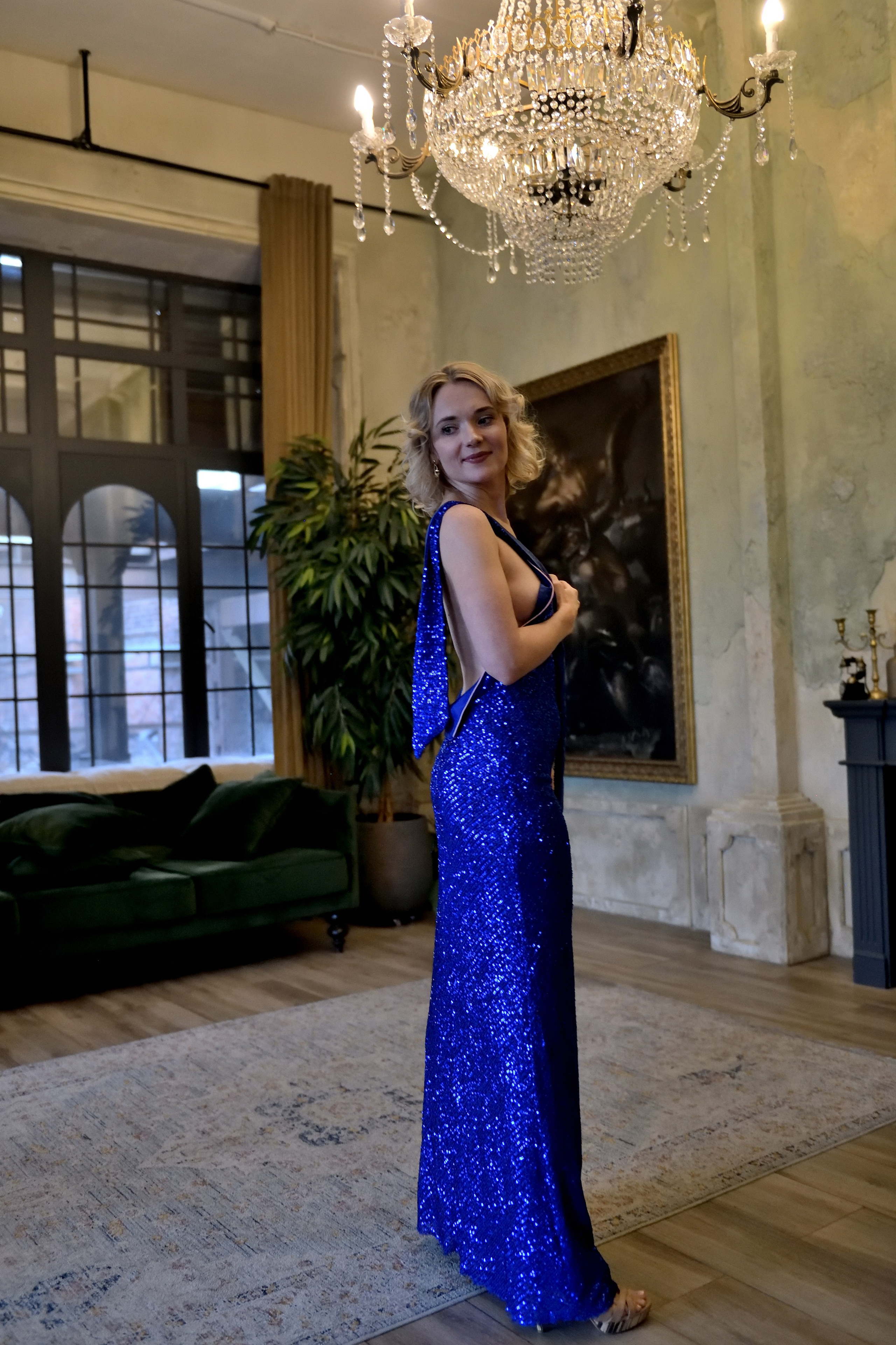 Девушка в красивом синем платье на фоне красивого интерьера.