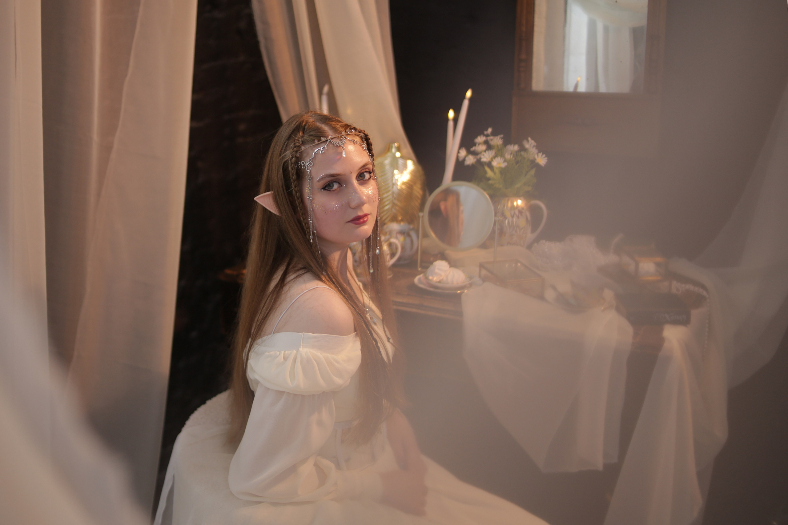 Необычнаяфотосессия в Перми: девушка в белом платье смотрит в камеру сквозь полупрозрачные занавески