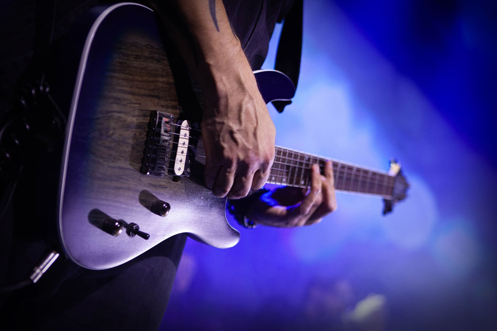 guitarist-playing-electric-guitar-on-stage-with-dramatic-lighting