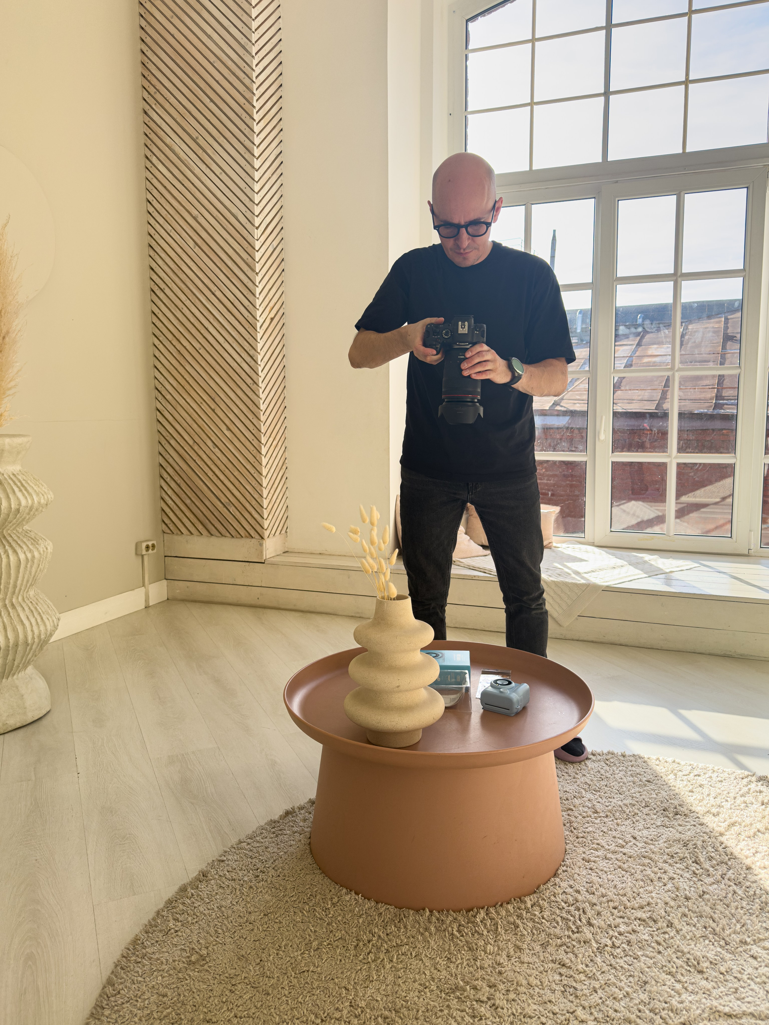 Фотограф проводит предметную фотосъёмку в интерьерной фотостудии