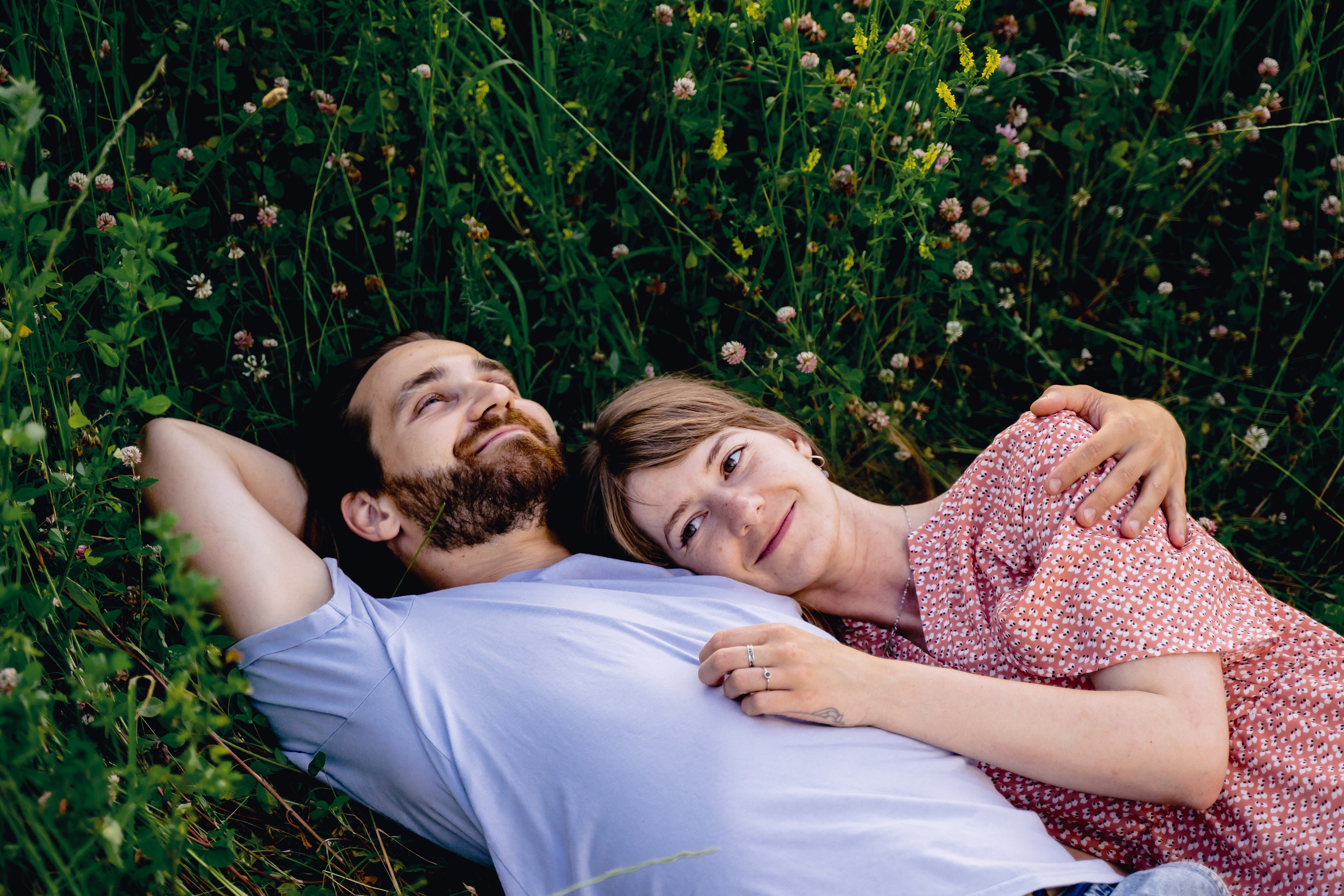 кадр девушки и парня лежут на траве 