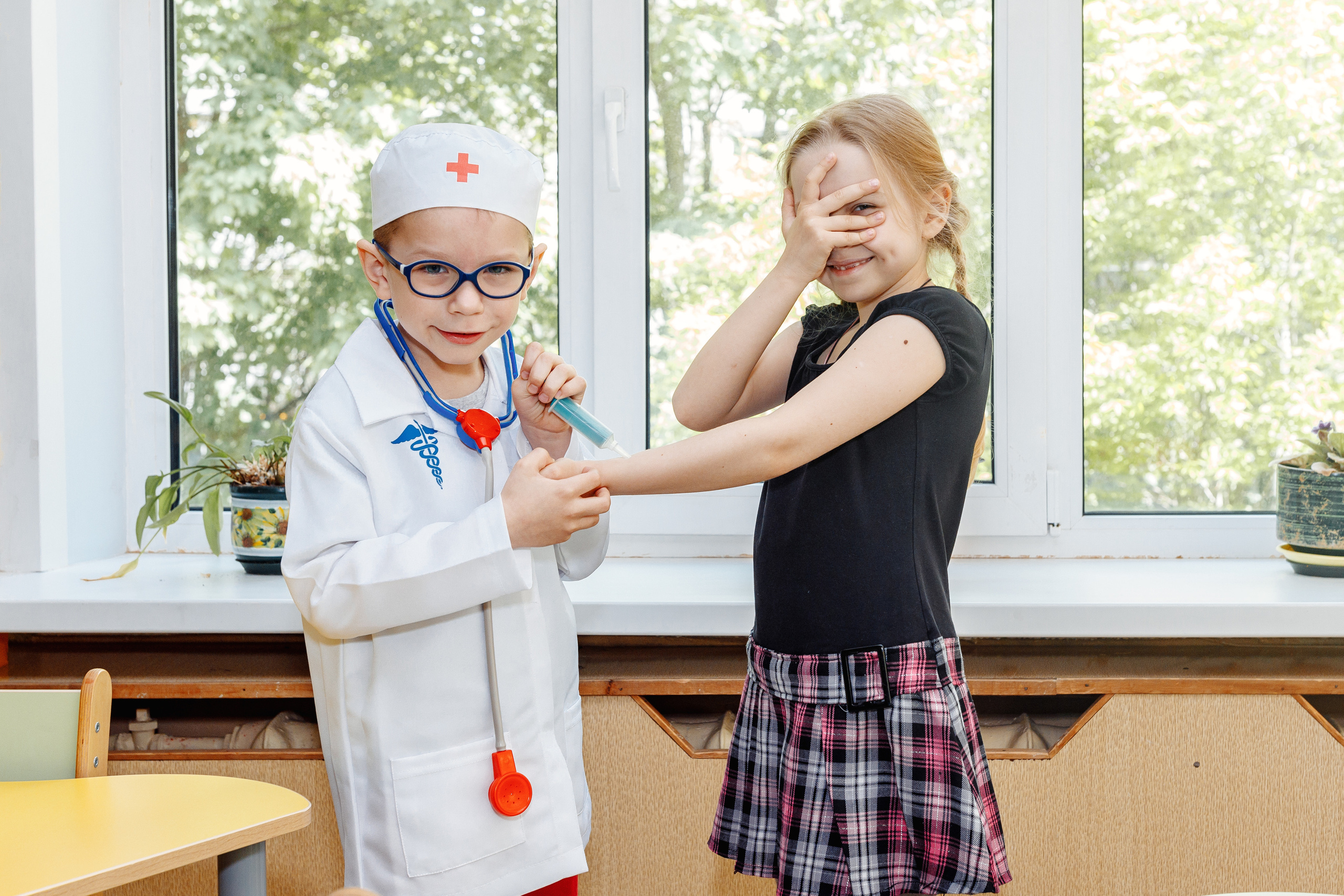 Мальчик и девочка в детском саду играют в доктора и пациента