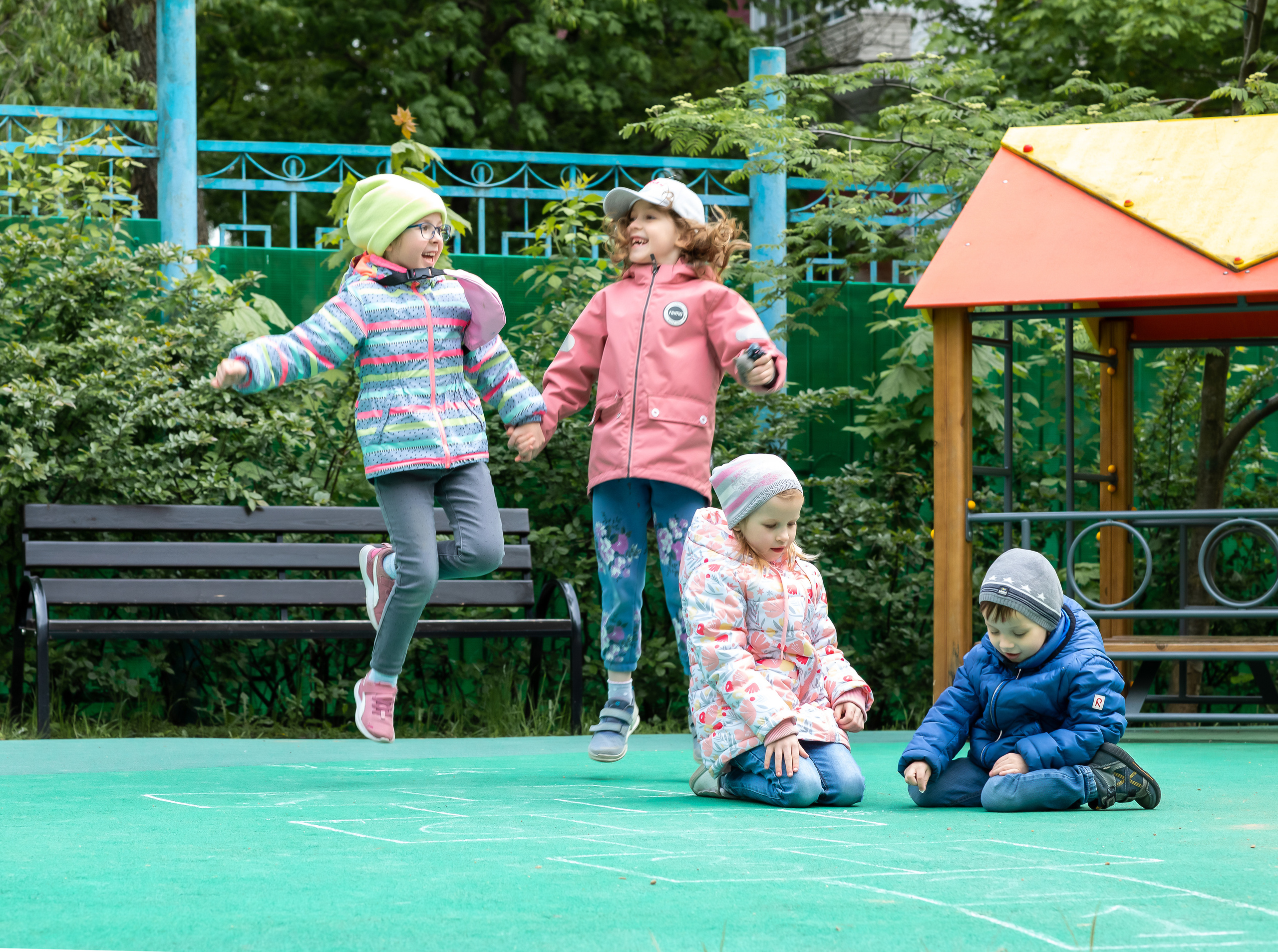 Девочки прыгают на детской площадке на улице