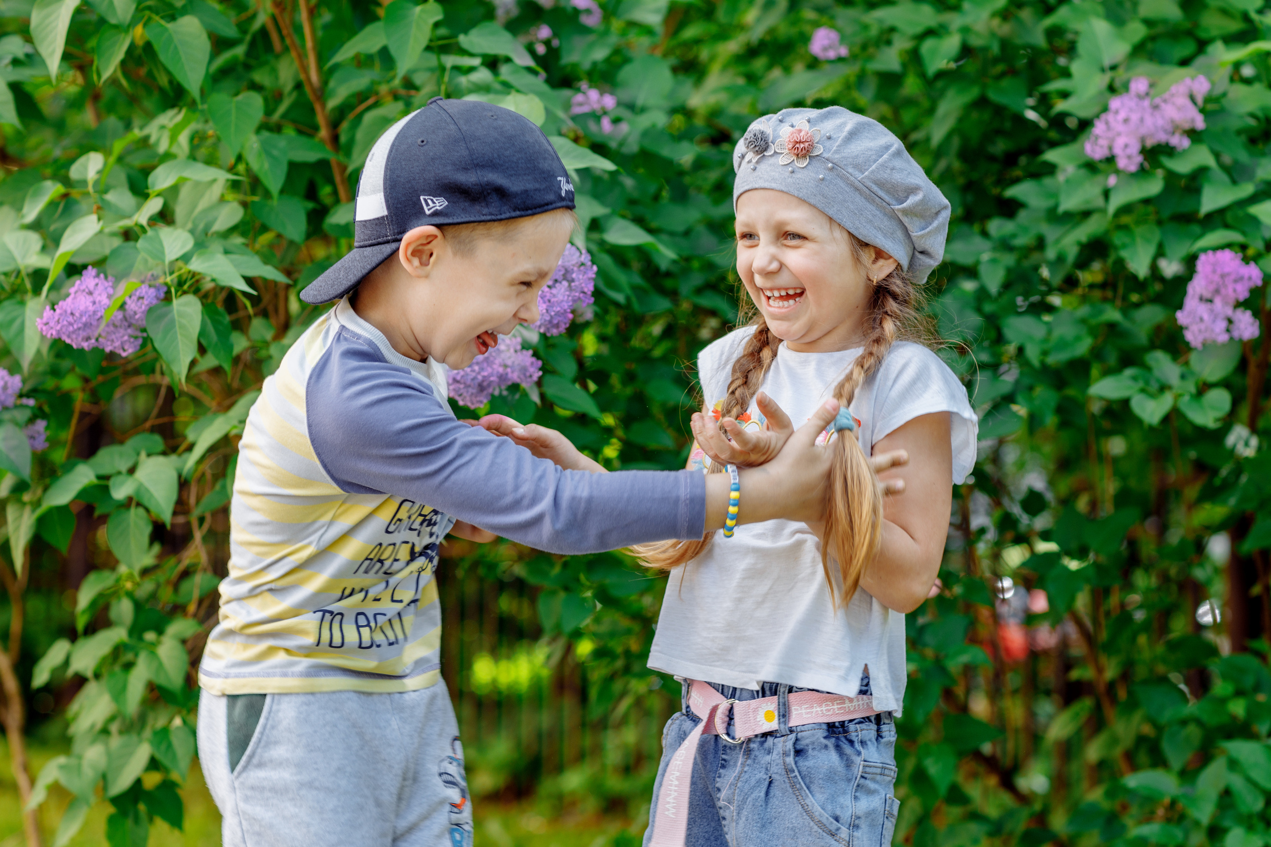 Мальчик с девочкой смеются на улице. Детский сад.