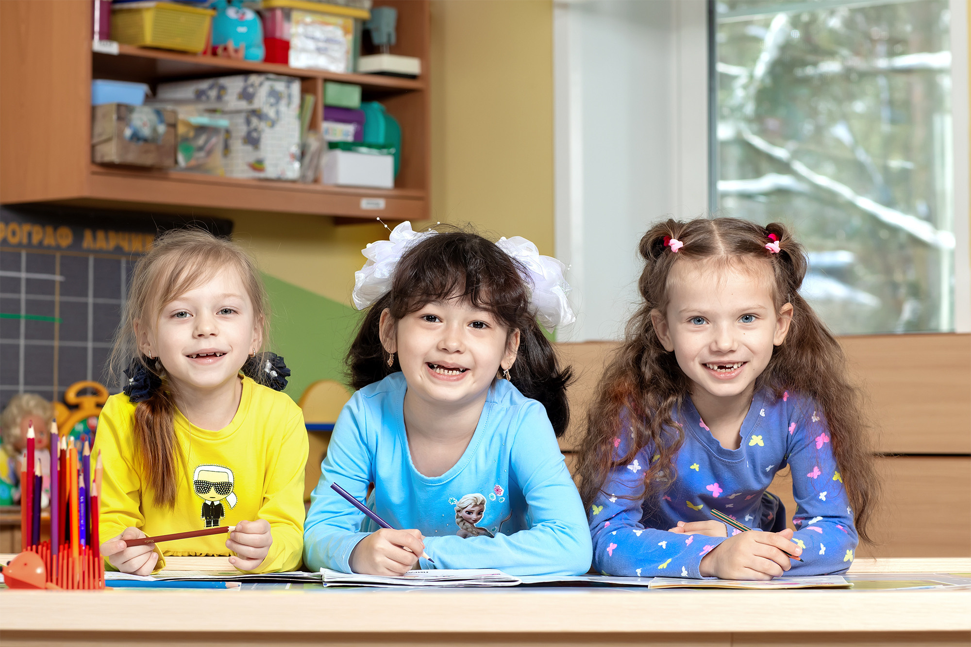 Три девочки за столом в игровой комнате