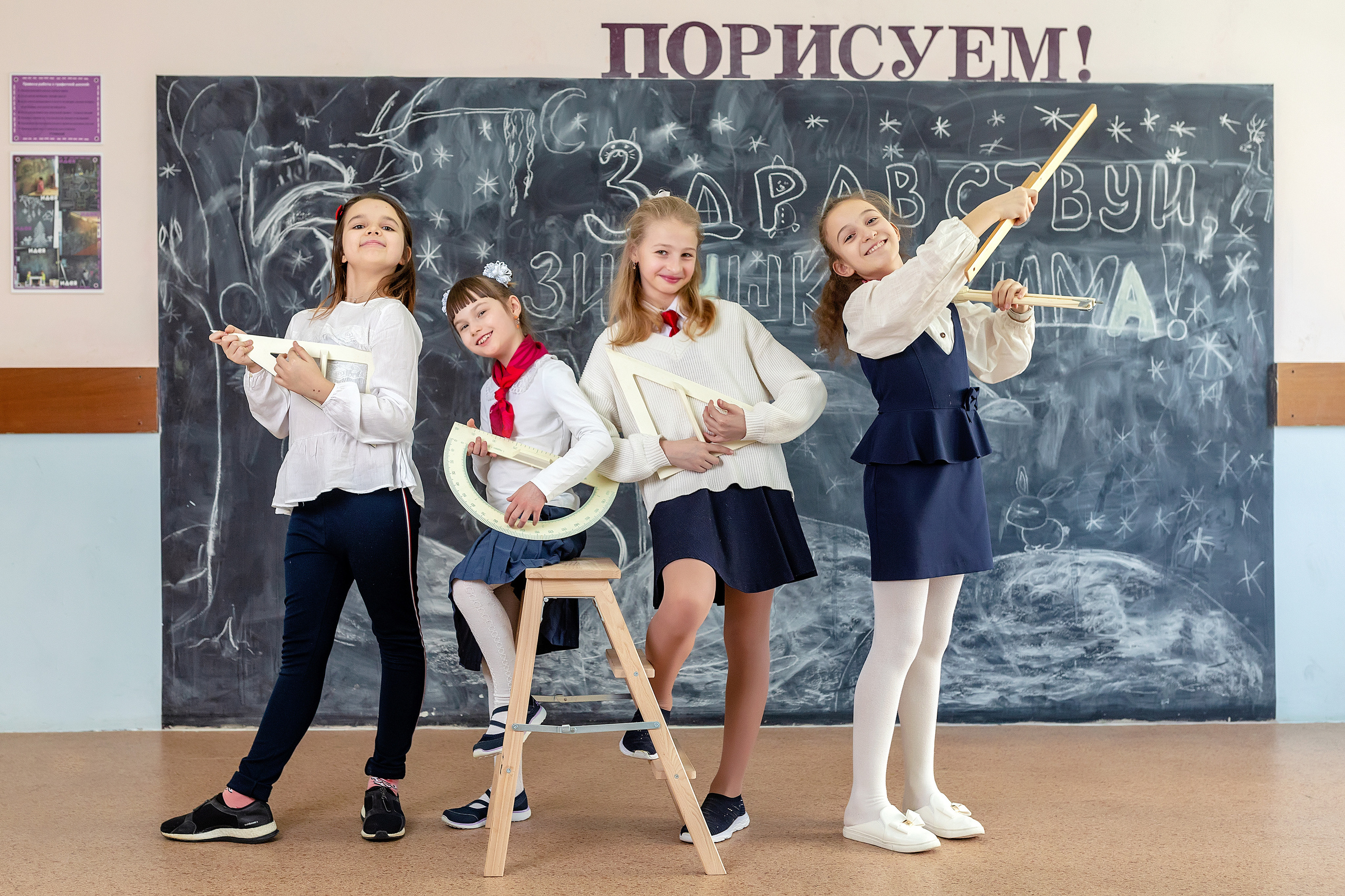 Четыре девочки в рекреации школы имитируют игру на музыкальных инструментах