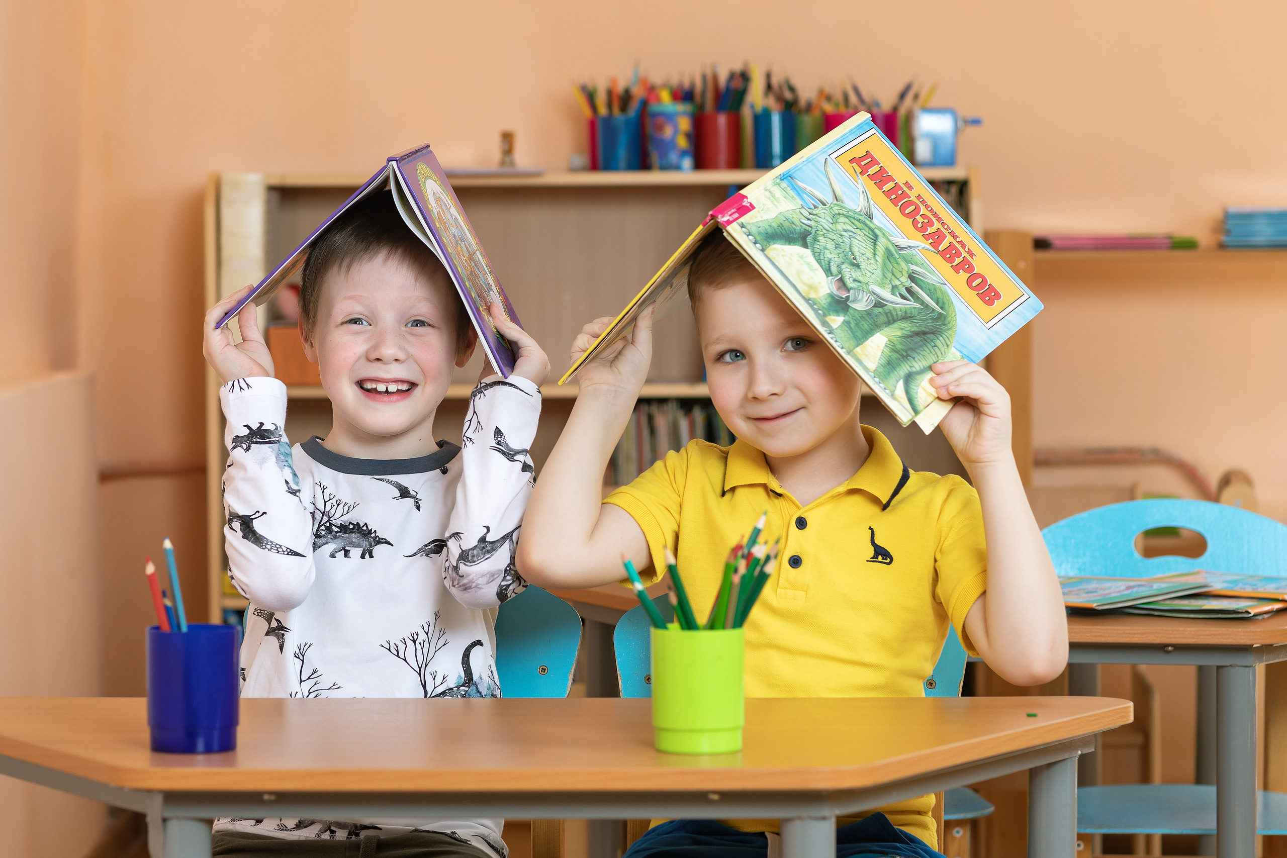 Мальчишки в детском саду с книжками на голове