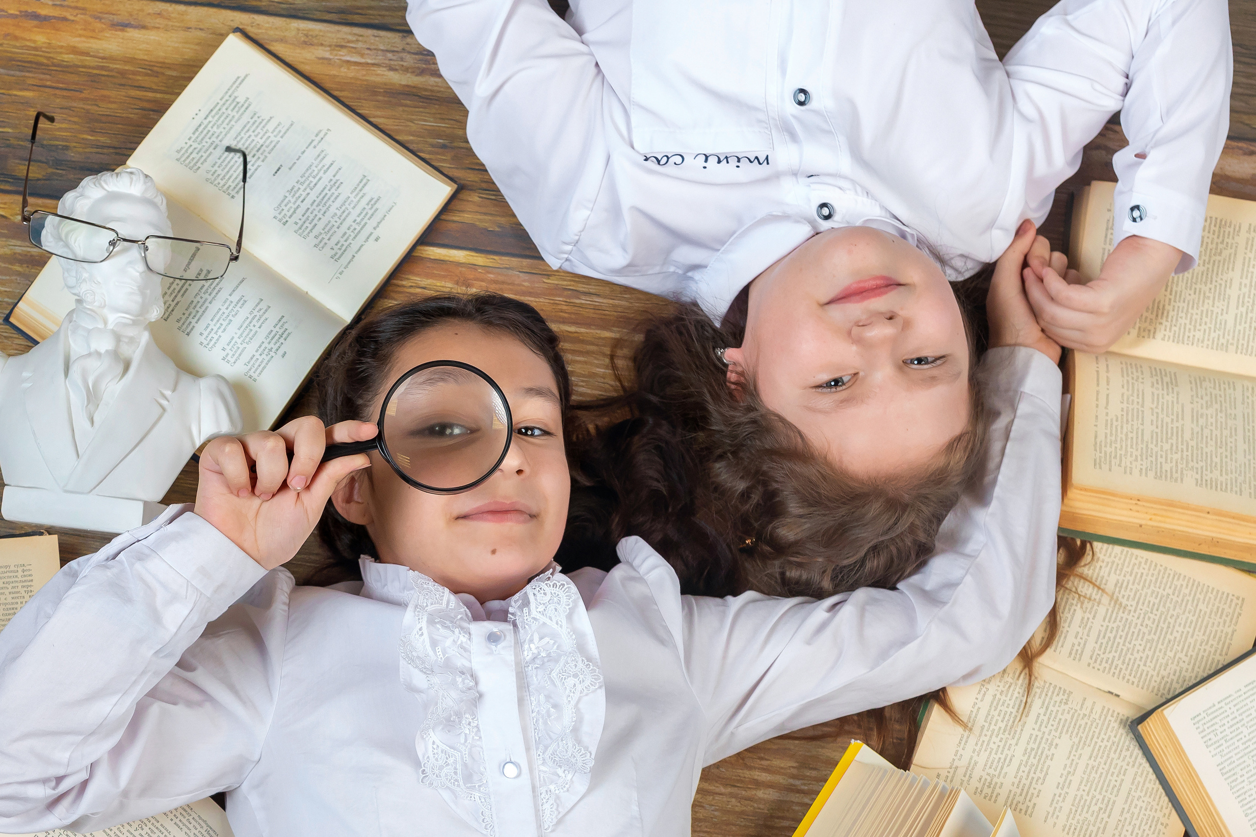 Коллаж - две девочки  на полу среди учебников и тетрадей