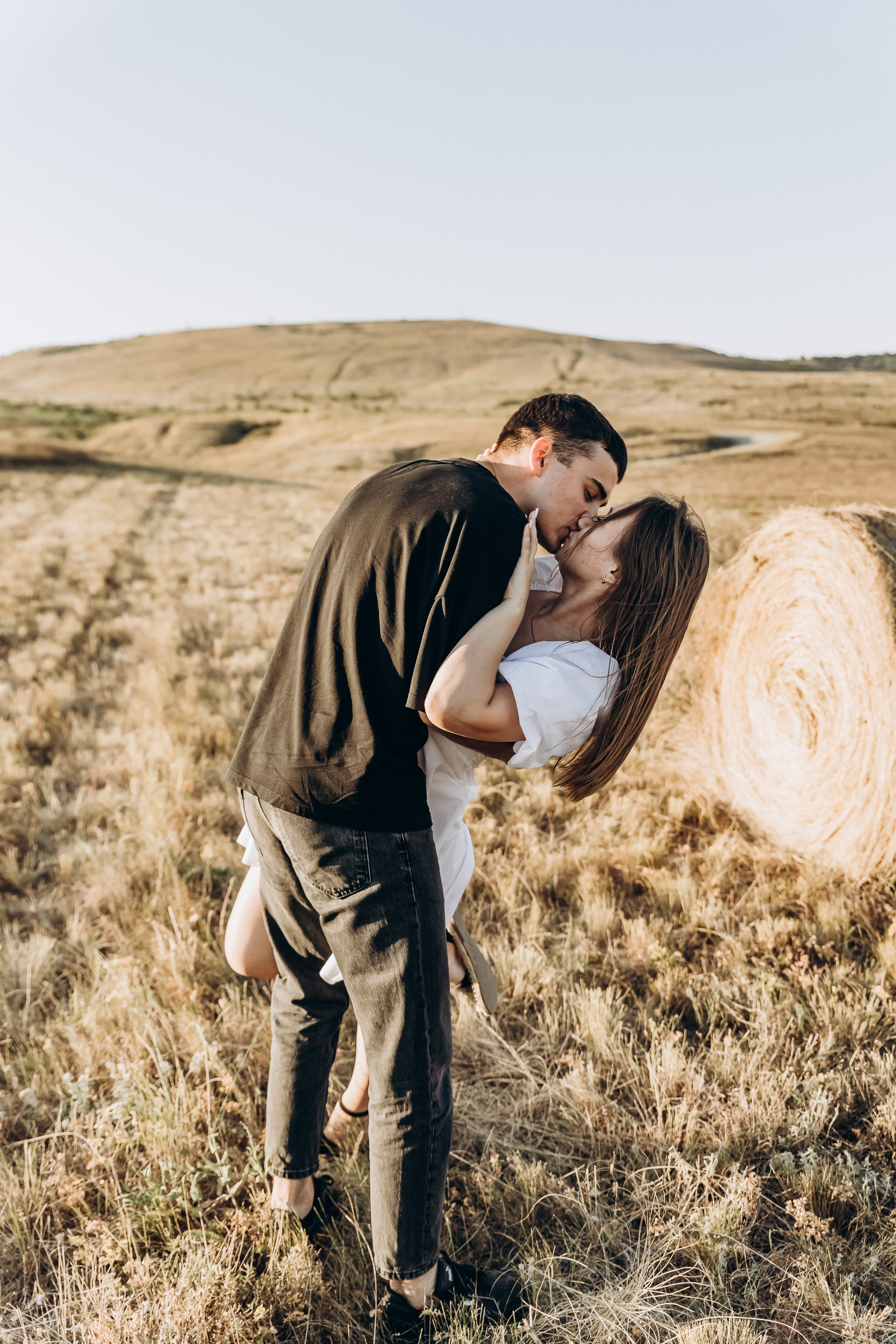 Крупный план нежного поцелуя пары на фоне зеленого сада